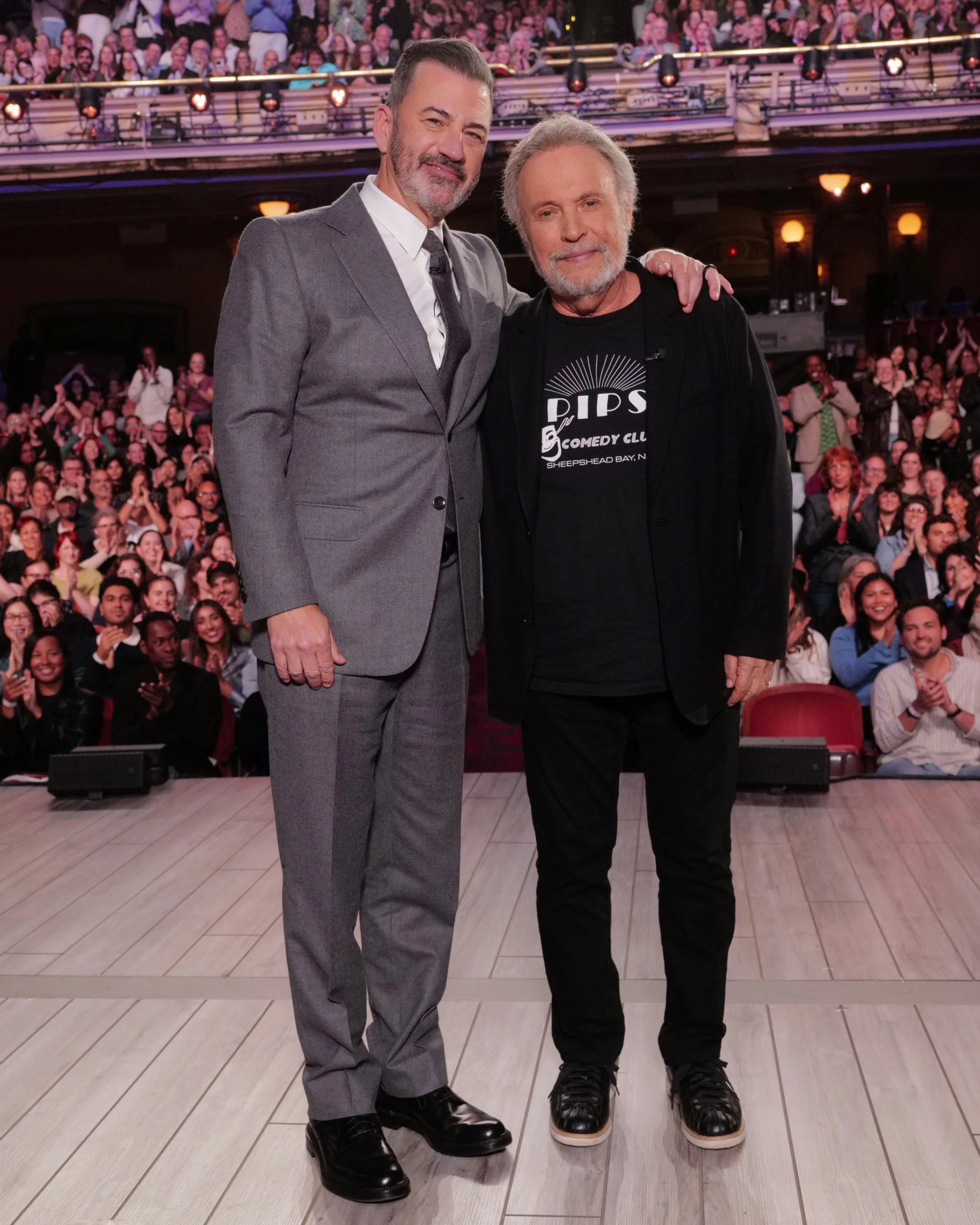 Billy Crystal and Jimmy Kimmel stand together in front of the studio audience.
