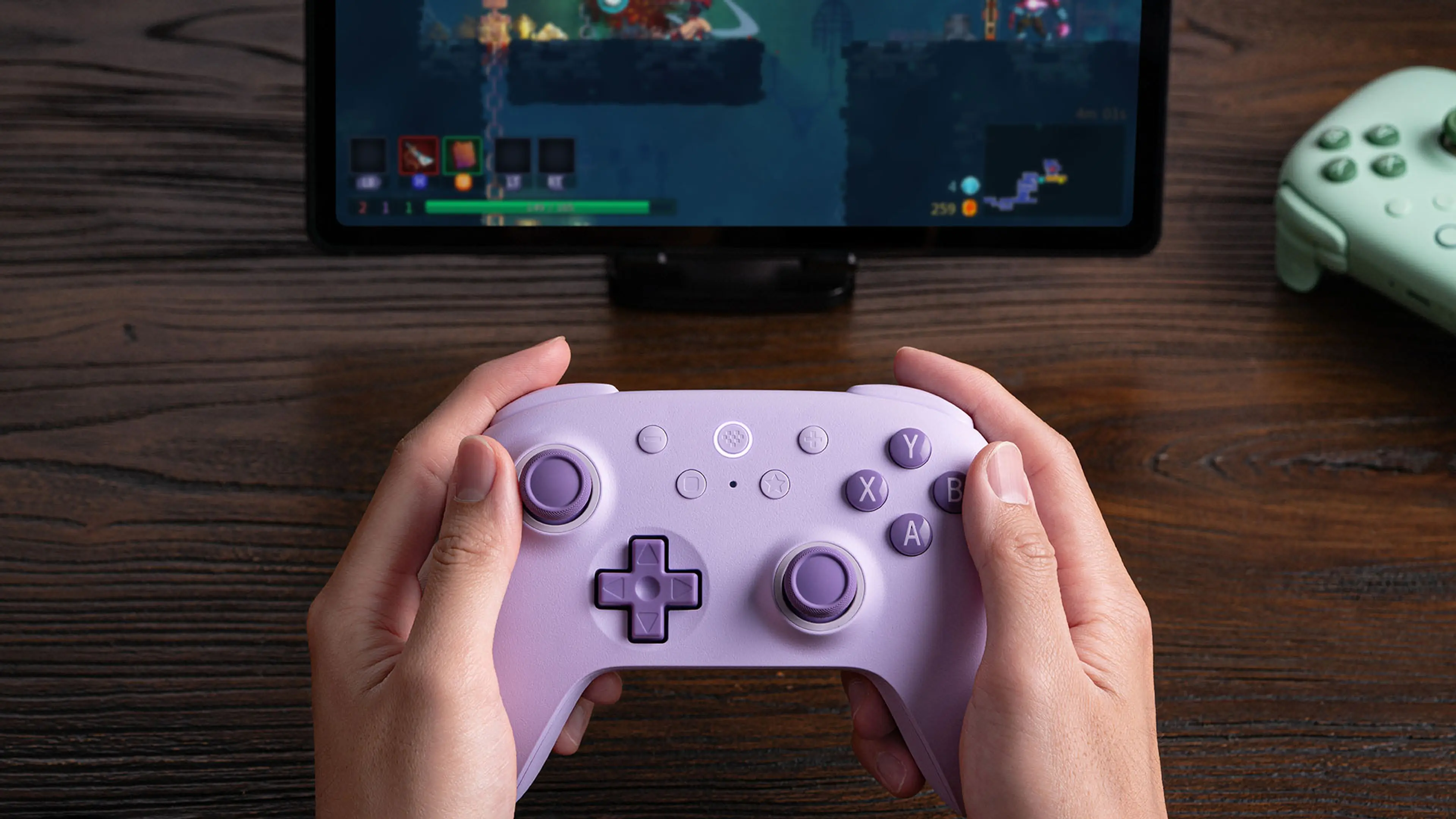 Purple Ultimate 2C Wireless held in front of a tablet running a game