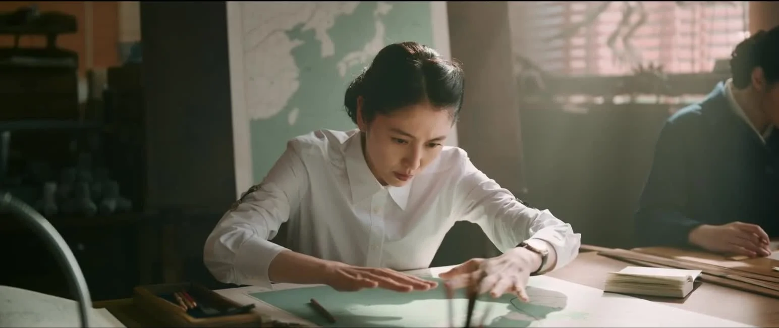 Masami Nagasawa as Makoto Aoyama studies a map at a desk in Godzilla Minus Zero.