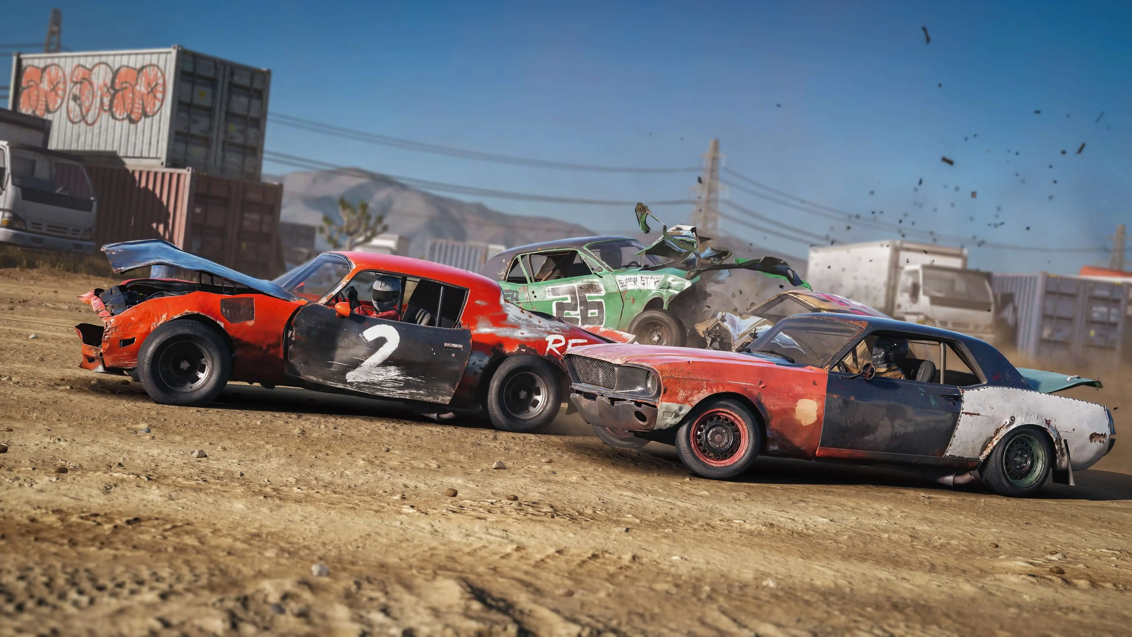 Several battered cars race through a muddy corner.