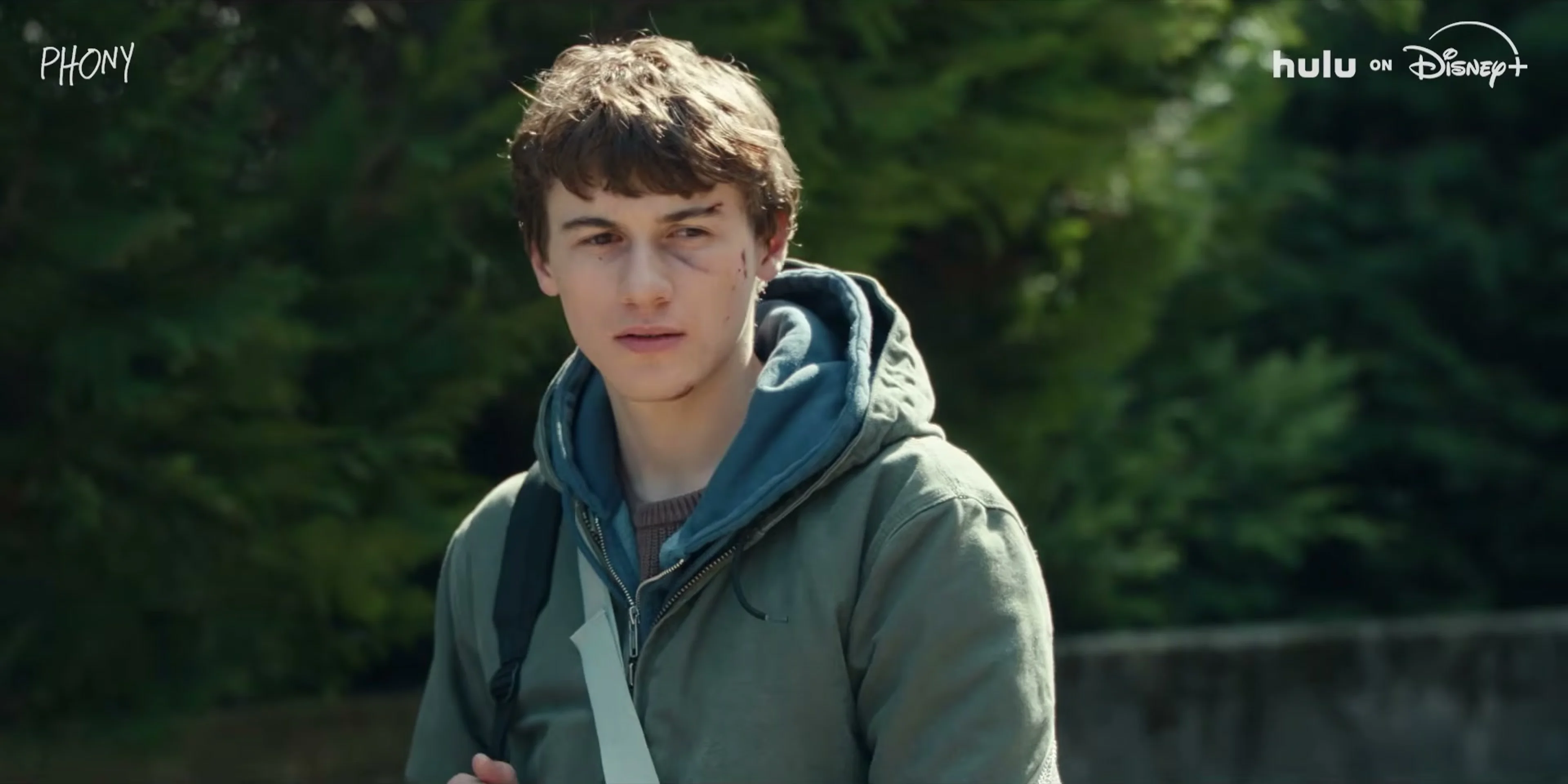 Sam Nivola stands outside in a hoodie in the Phony trailer.