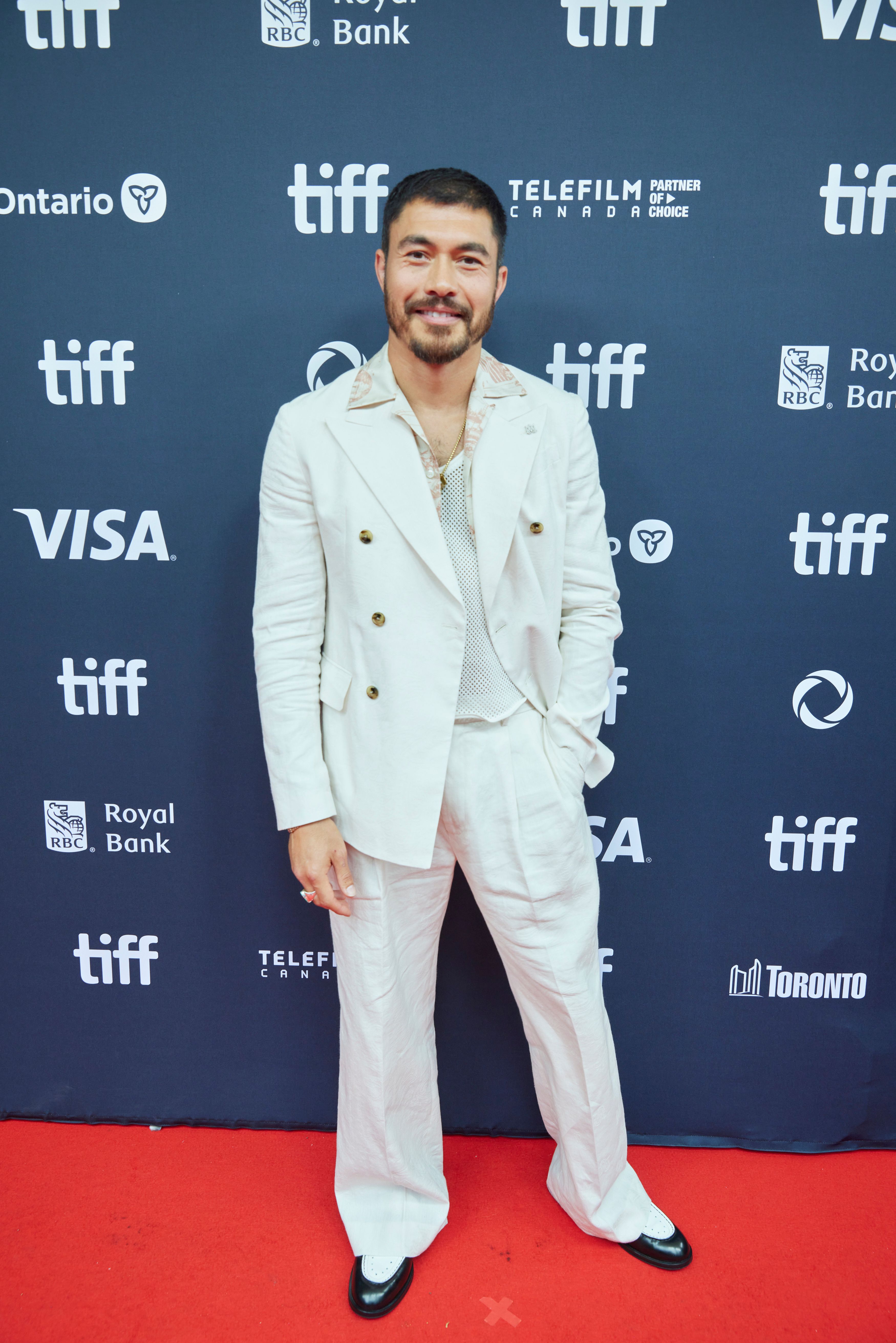 Henry Golding at the 2024 Toronto International Film Festival in a white suit.