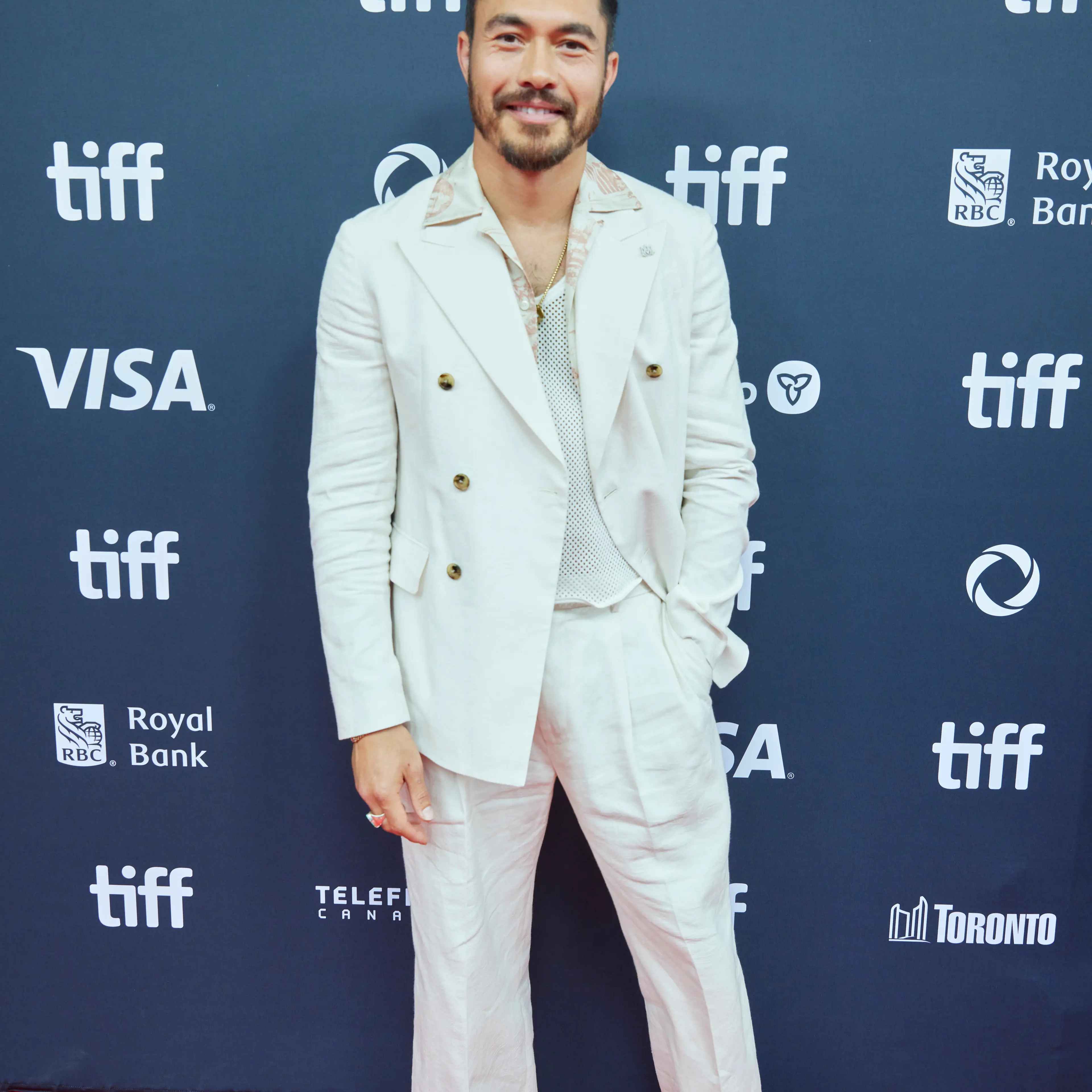 Henry Golding at the 2024 Toronto International Film Festival in a white suit.
