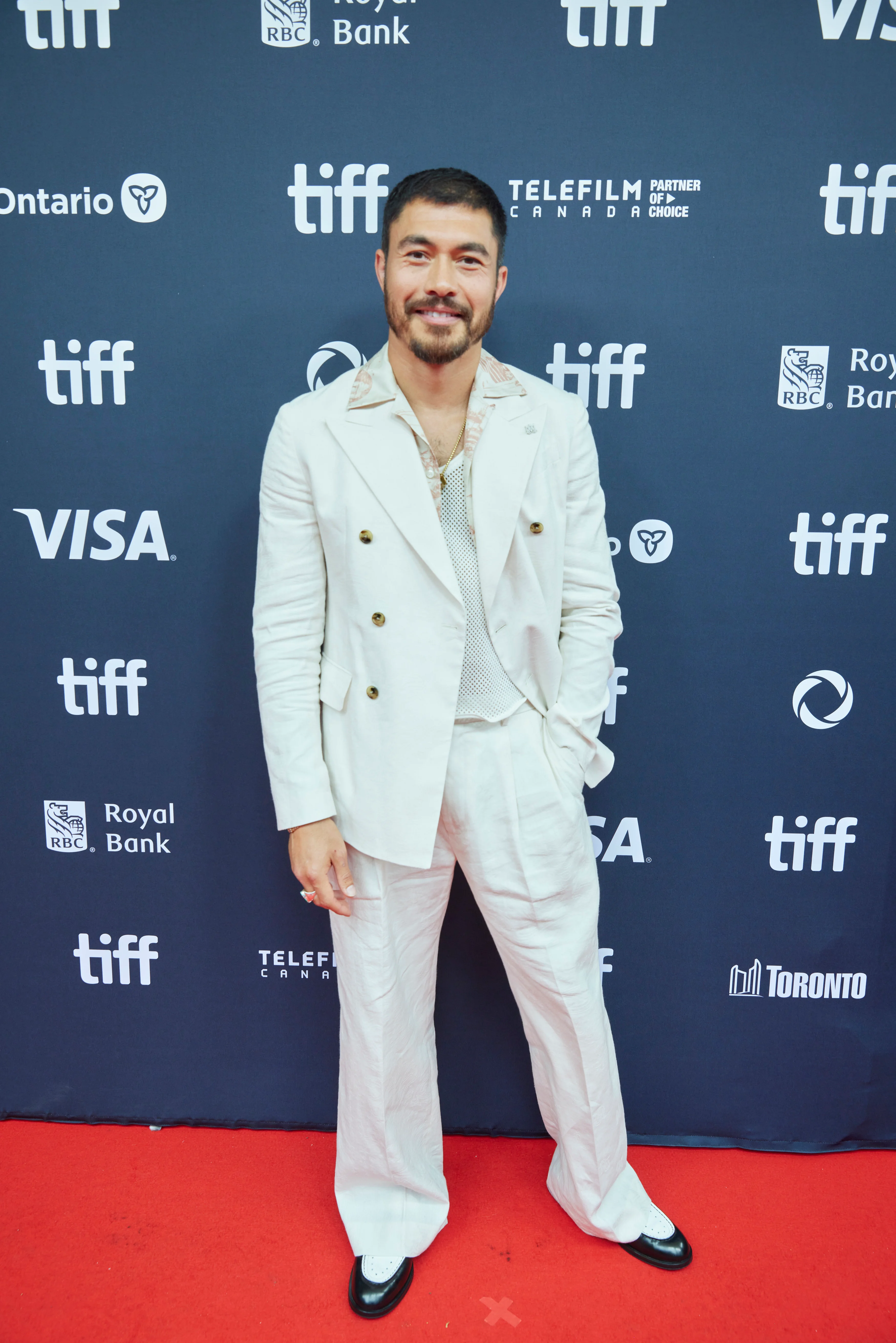 Henry Golding at the 2024 Toronto International Film Festival in a white suit.