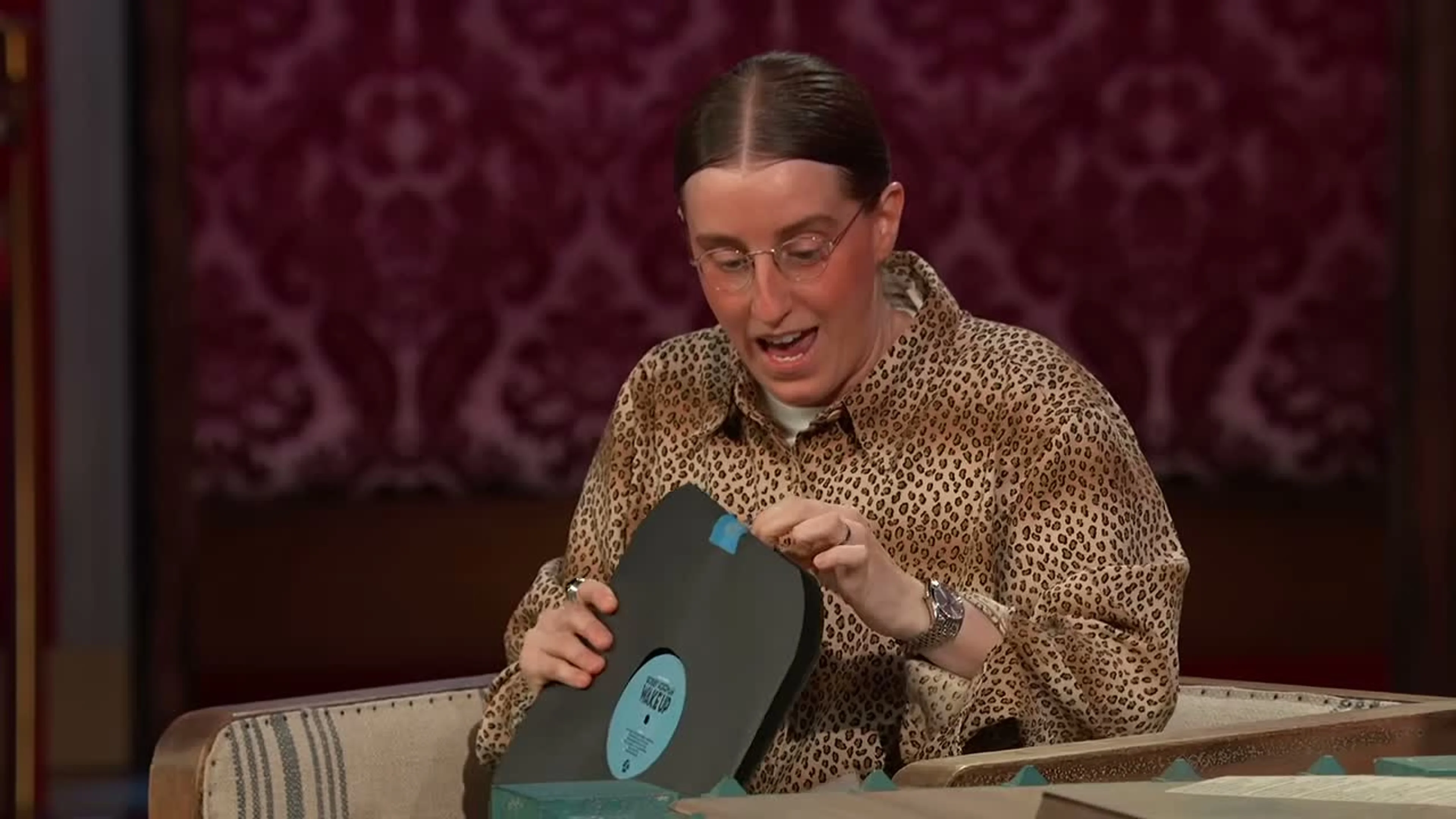 Robby Hoffman holds a black Wake Up record partly out of its sleeve on Jimmy Kimmel Live.