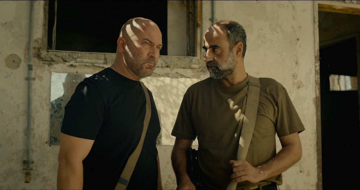 Doron and Eli stand inside a worn building in Fauda Season 5.