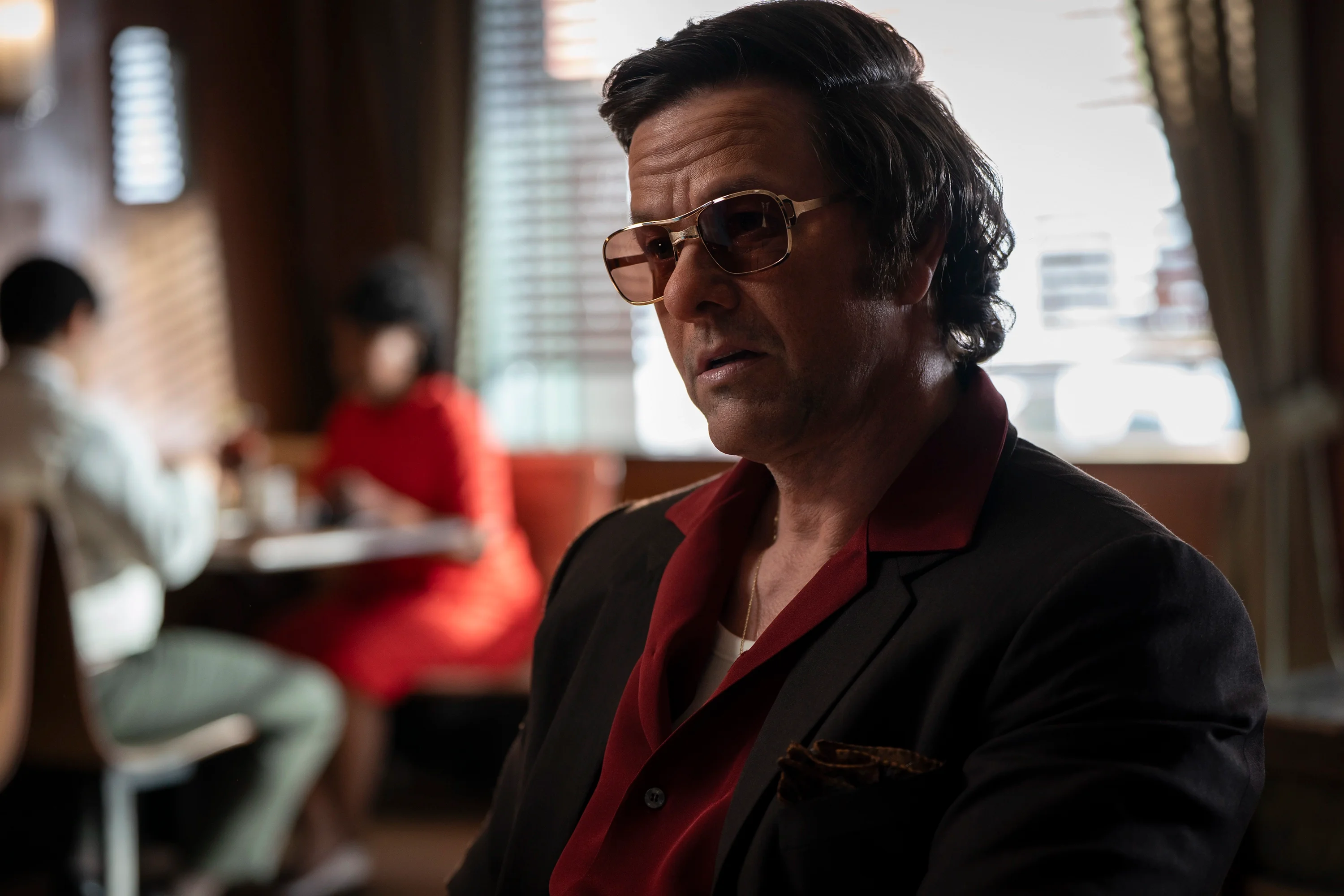 Mark Wahlberg as Greg Scarpa sits in a diner wearing tinted glasses in By Any Means.