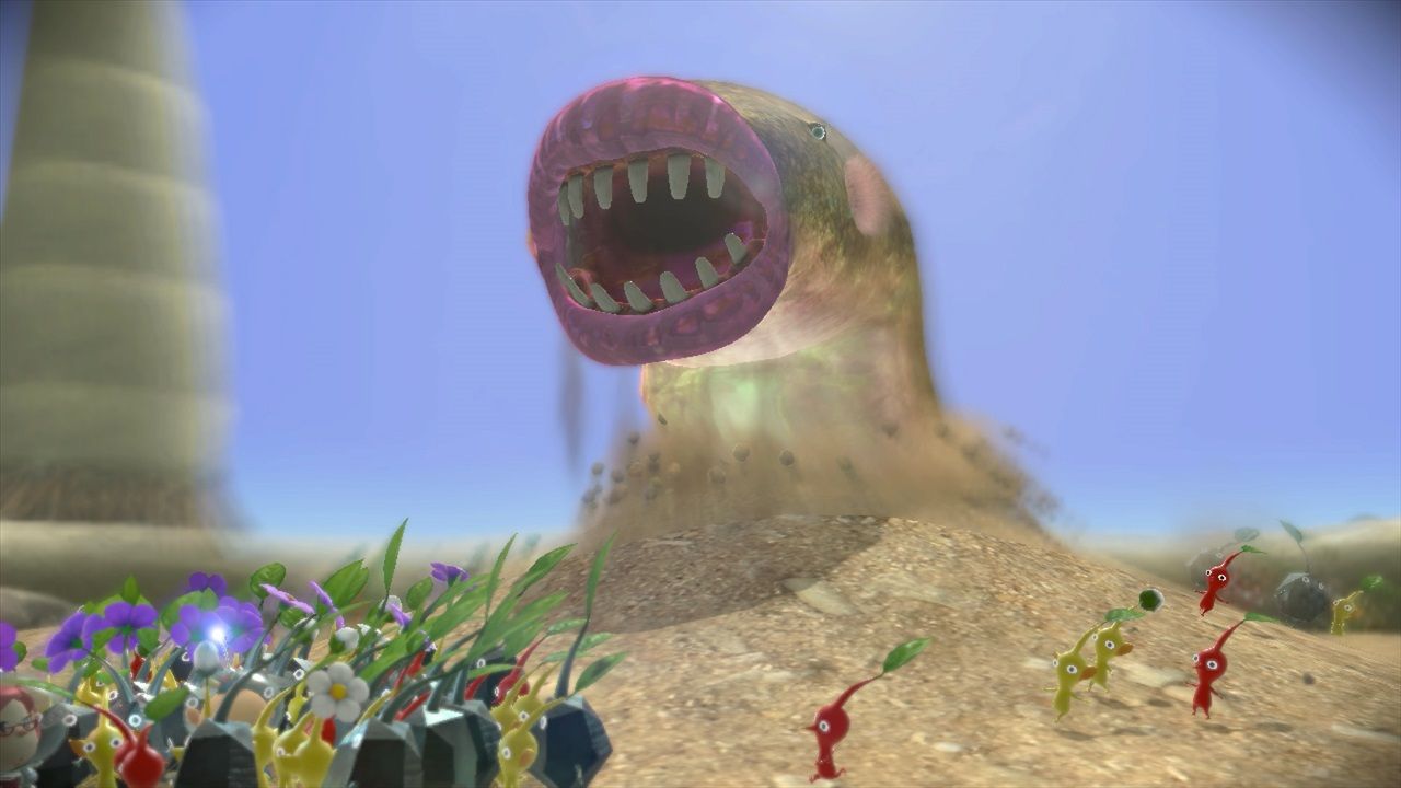 A large burrowing creature rises from sand while a group of Pikmin approaches.