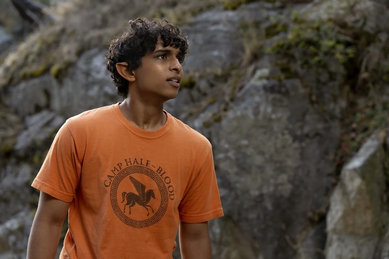 Aryan Simhadri as Grover Underwood stands outdoors in Percy Jackson and the Olympians Season 3.