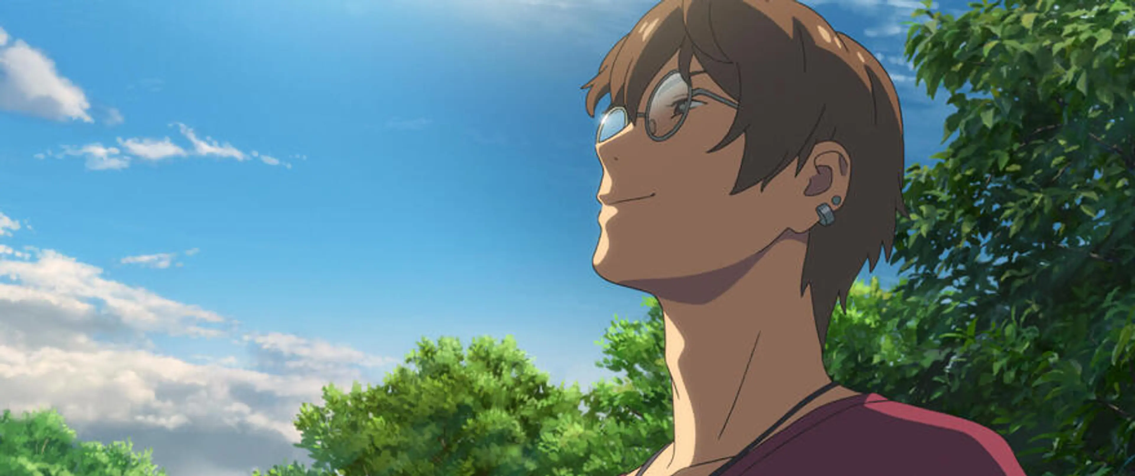 Serizawa, a young man with round glasses, looks up at the blue sky beside green trees.