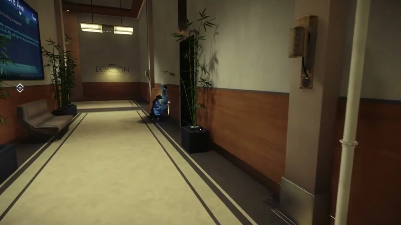 Bright apartment hallway with a door at the far end and a wall screen on the left.
