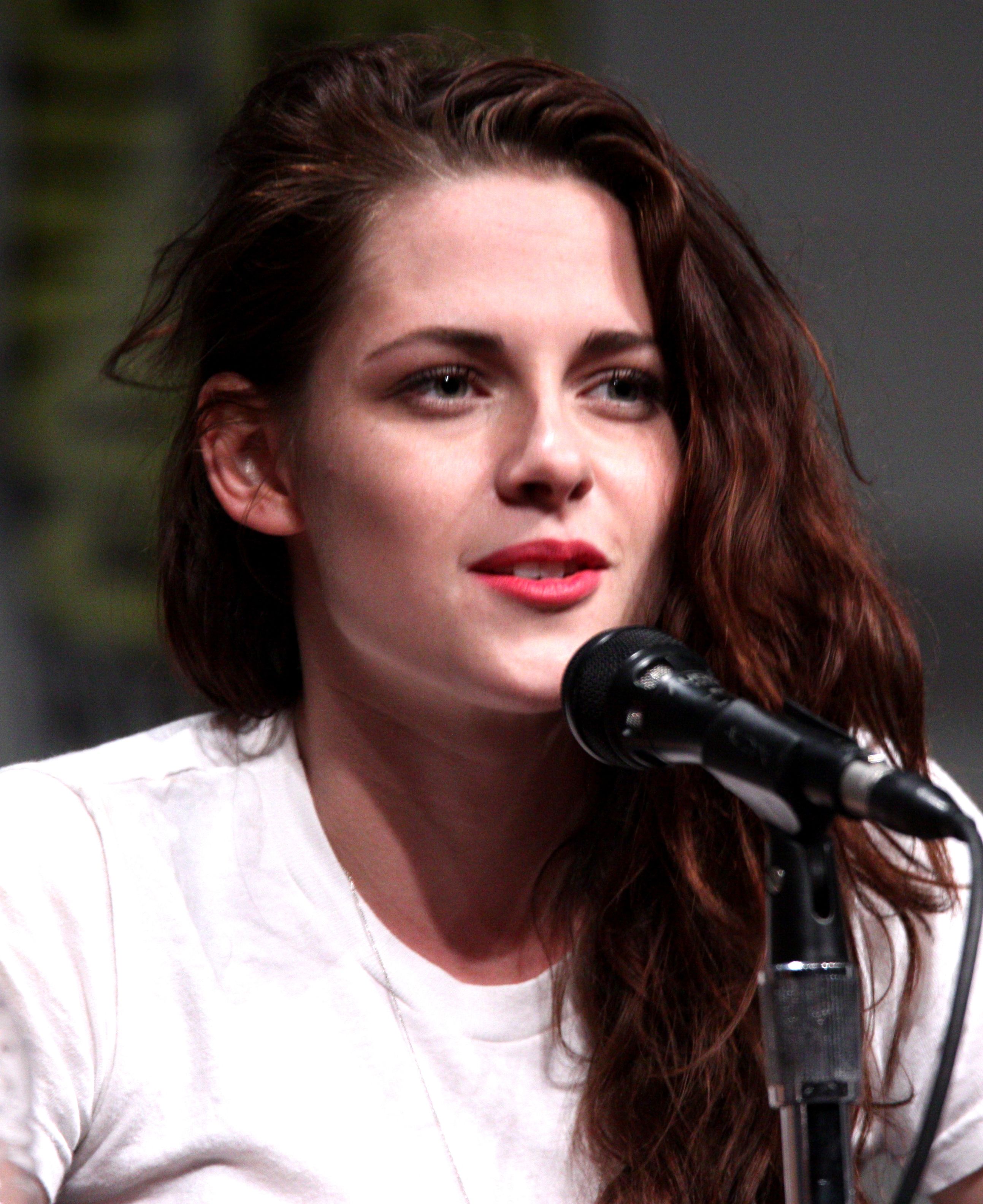 Kristen Stewart speaking into a microphone at a 2012 Comic-Con panel.