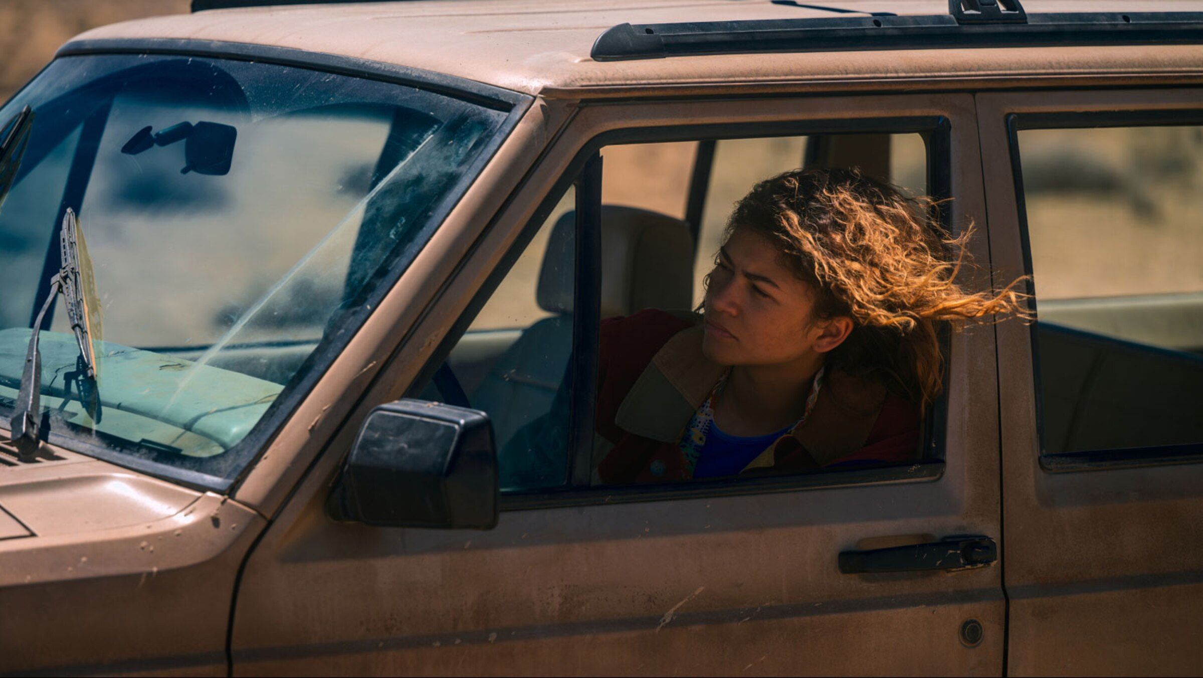 Zendaya as Rue looks from the window of a vehicle in an official HBO series still.