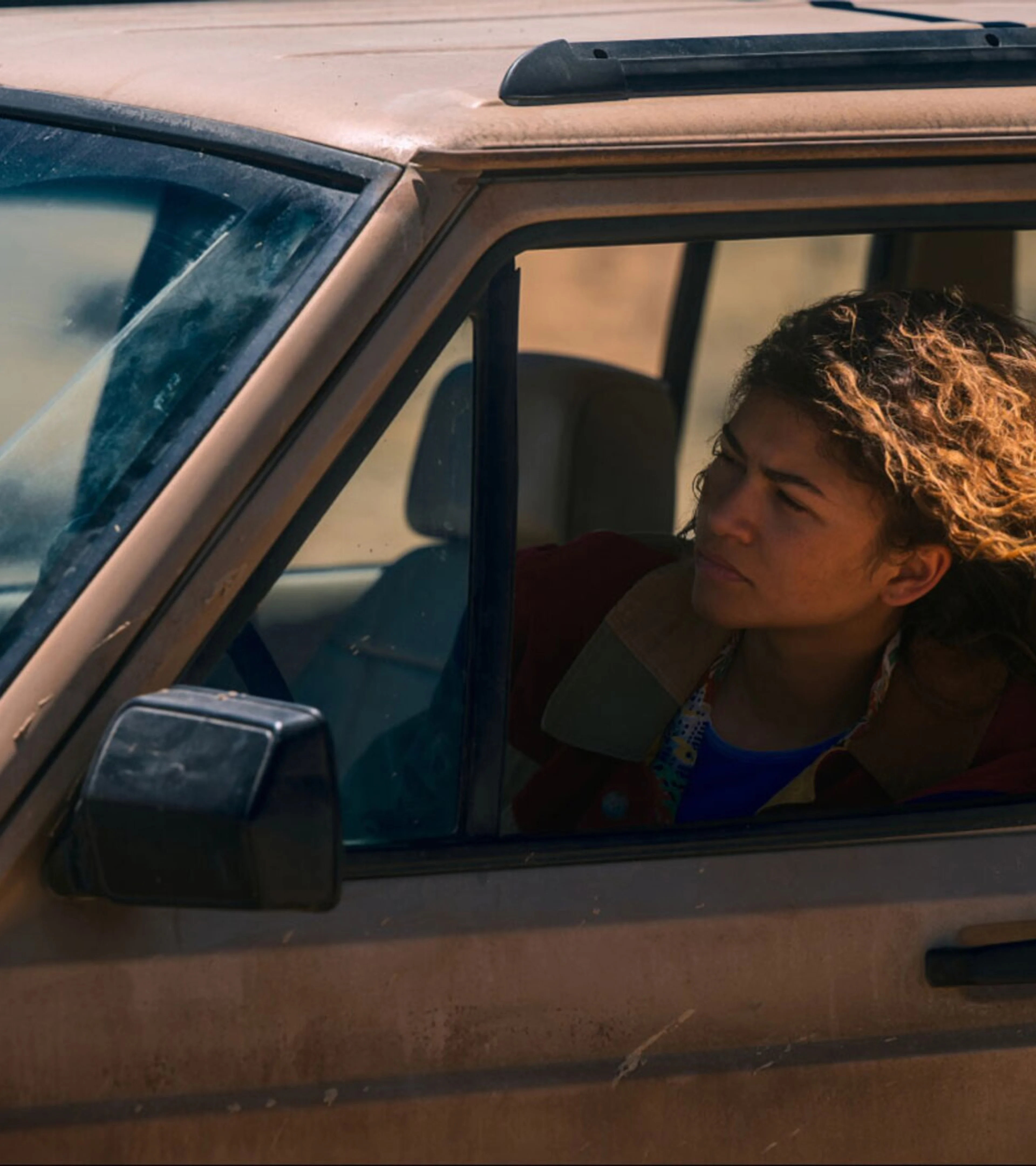 Zendaya as Rue looks from the window of a vehicle in an official HBO series still.