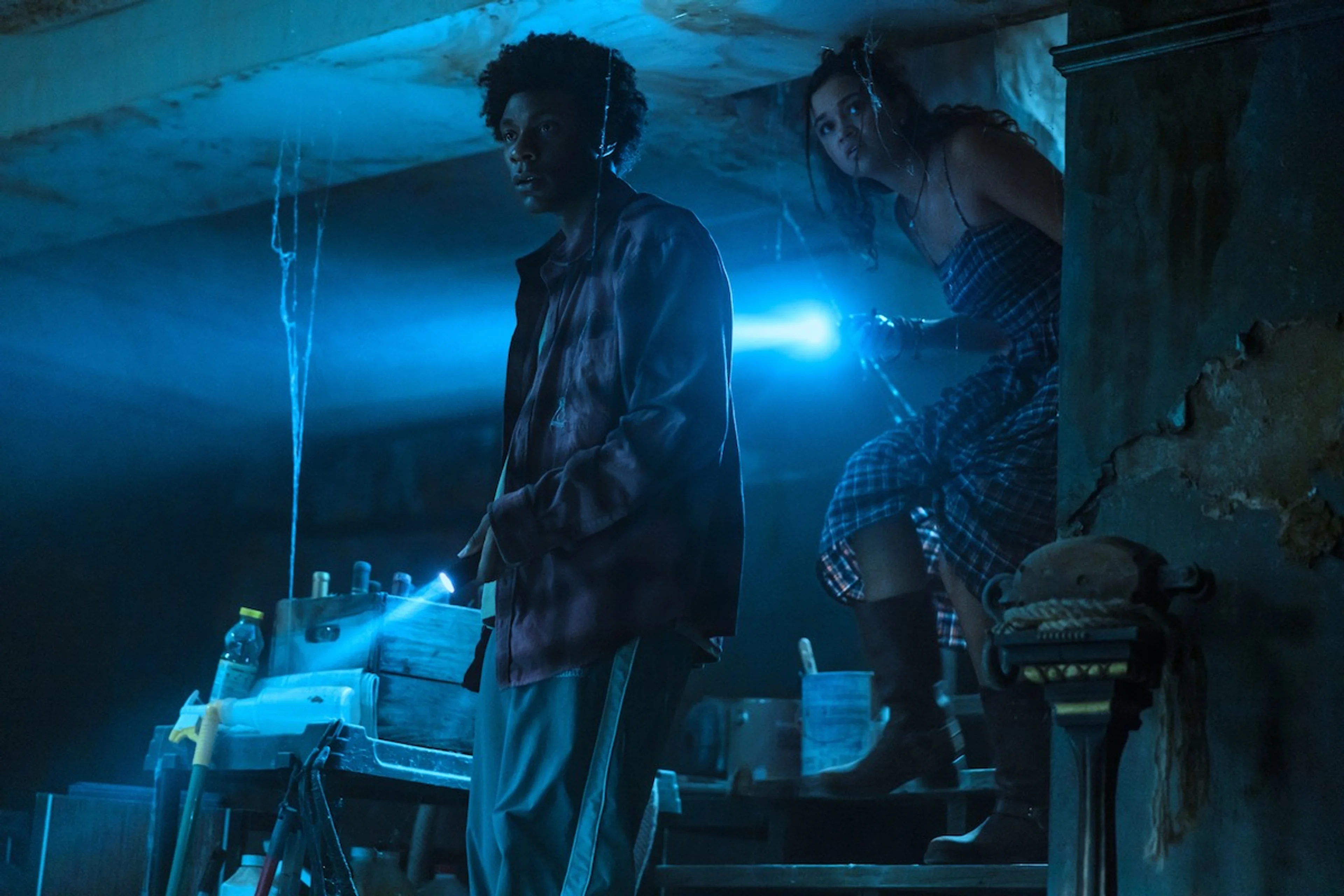 Pope and Cleo investigate a dark location in an official Outer Banks Season 5 still.