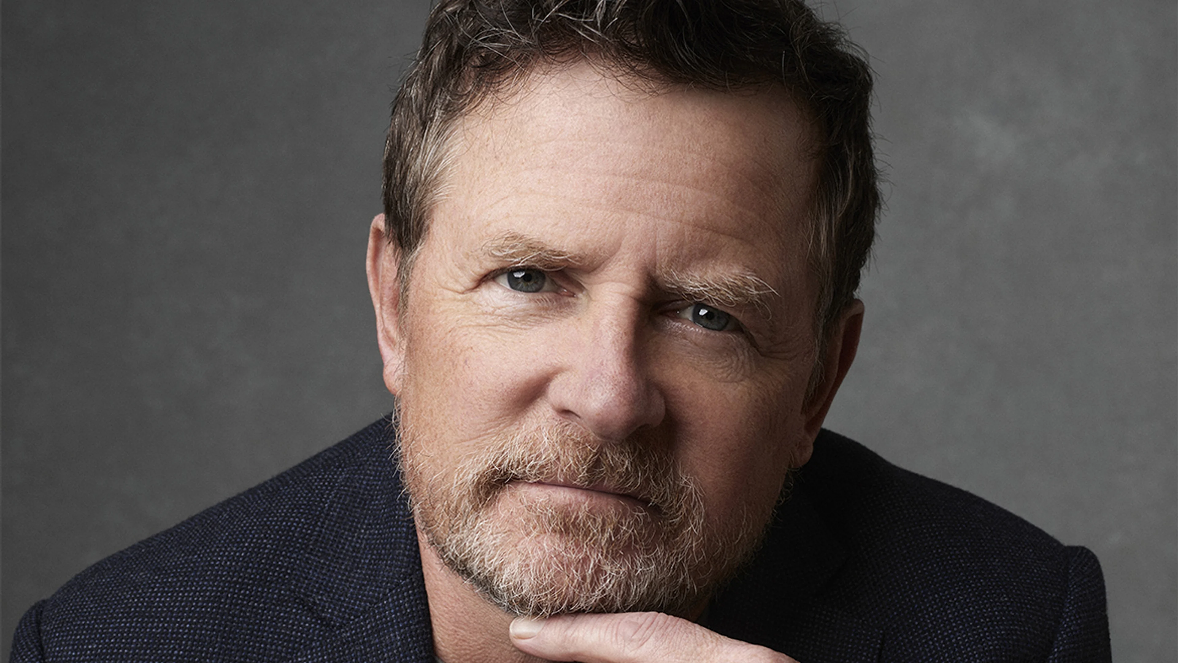Michael J. Fox looks toward the camera in an official portrait.