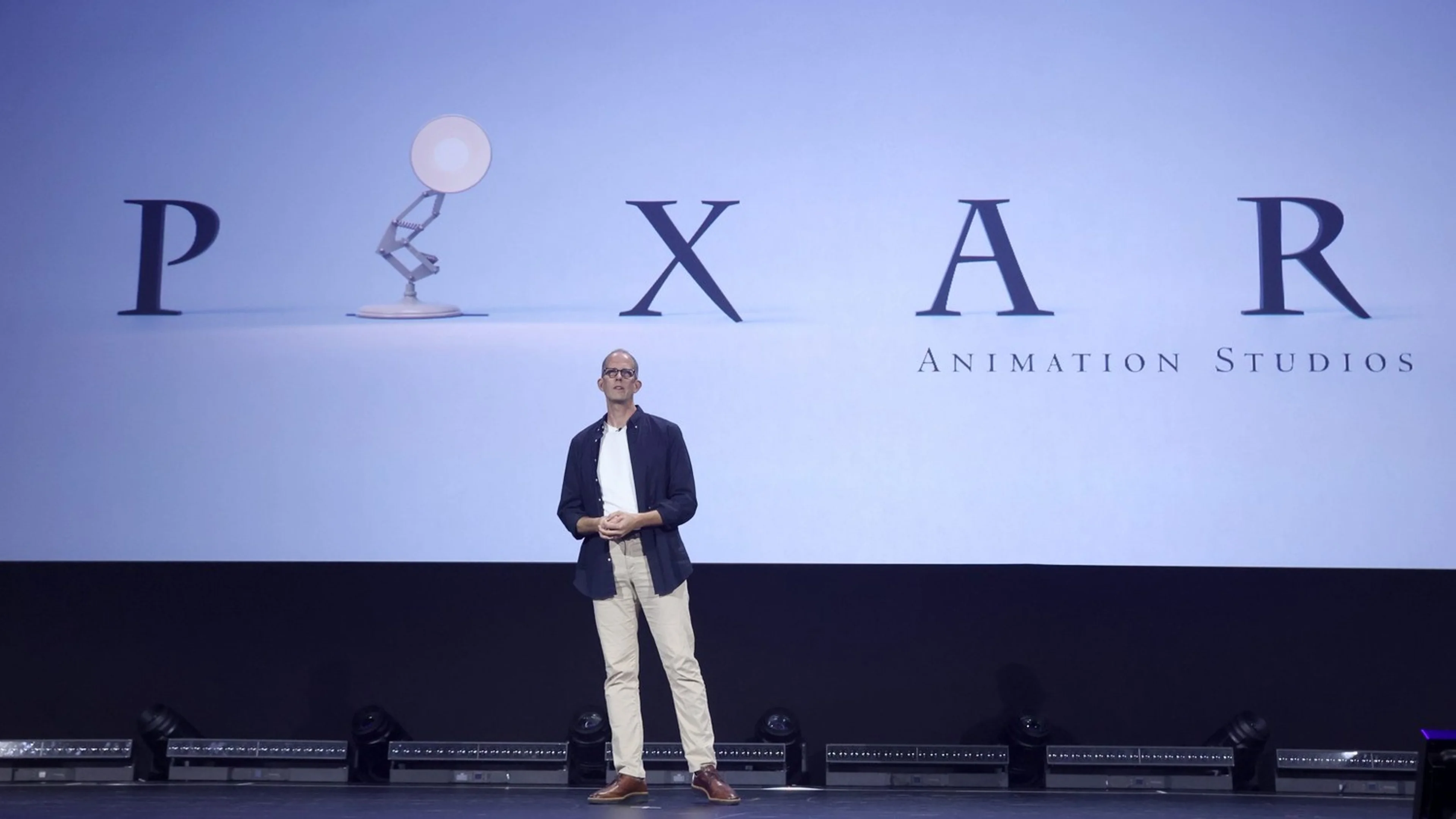 Pete Docter stands beneath the Pixar Animation Studios logo during an official studio presentation.