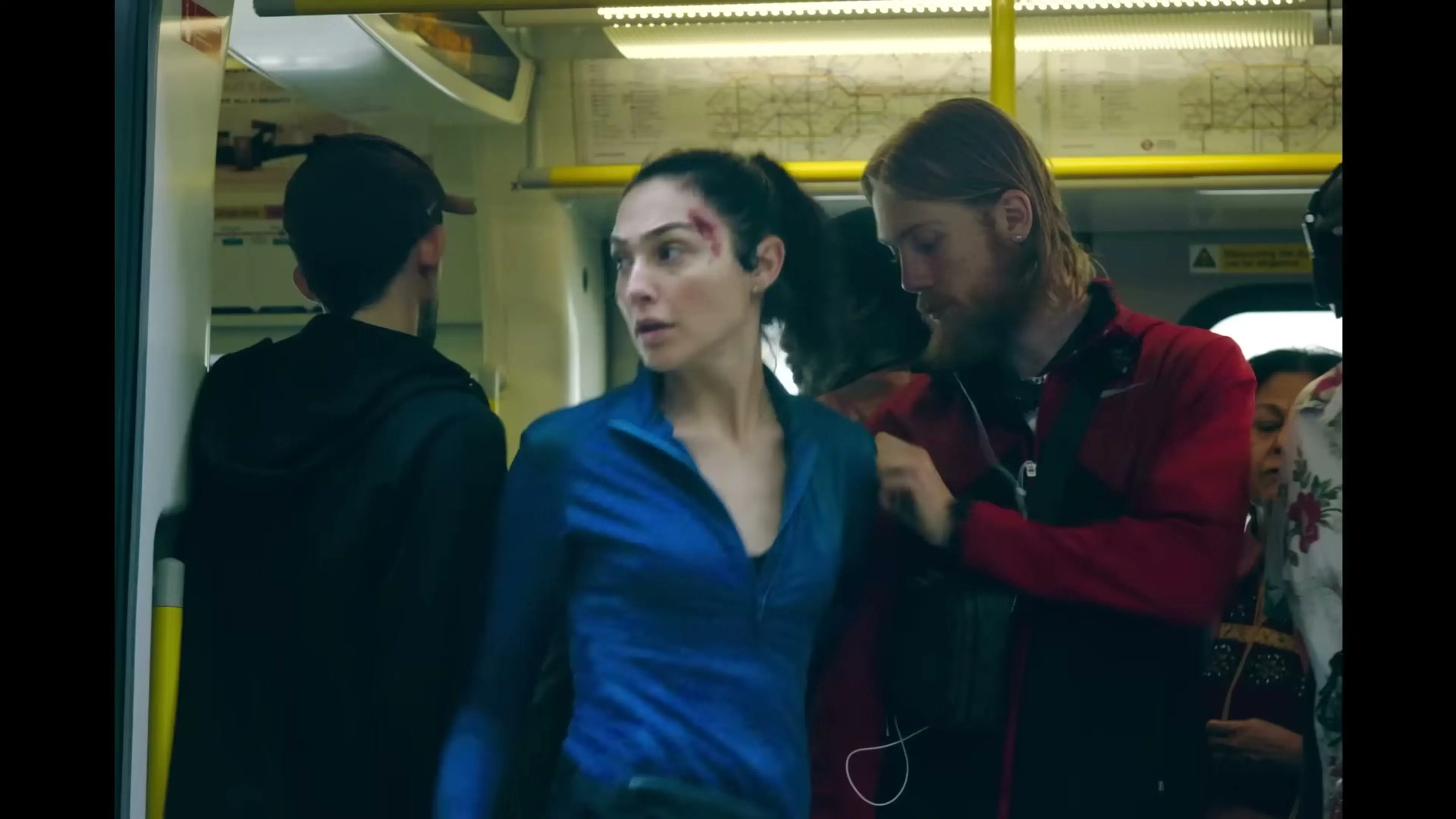 An Underground passenger helps an injured Maia Marten inside a train in The Runner.