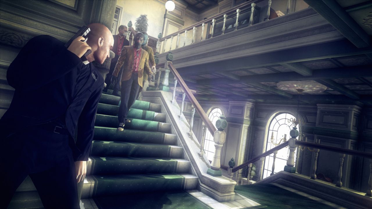Agent 47 holds a phone near a staircase as two men descend toward him.