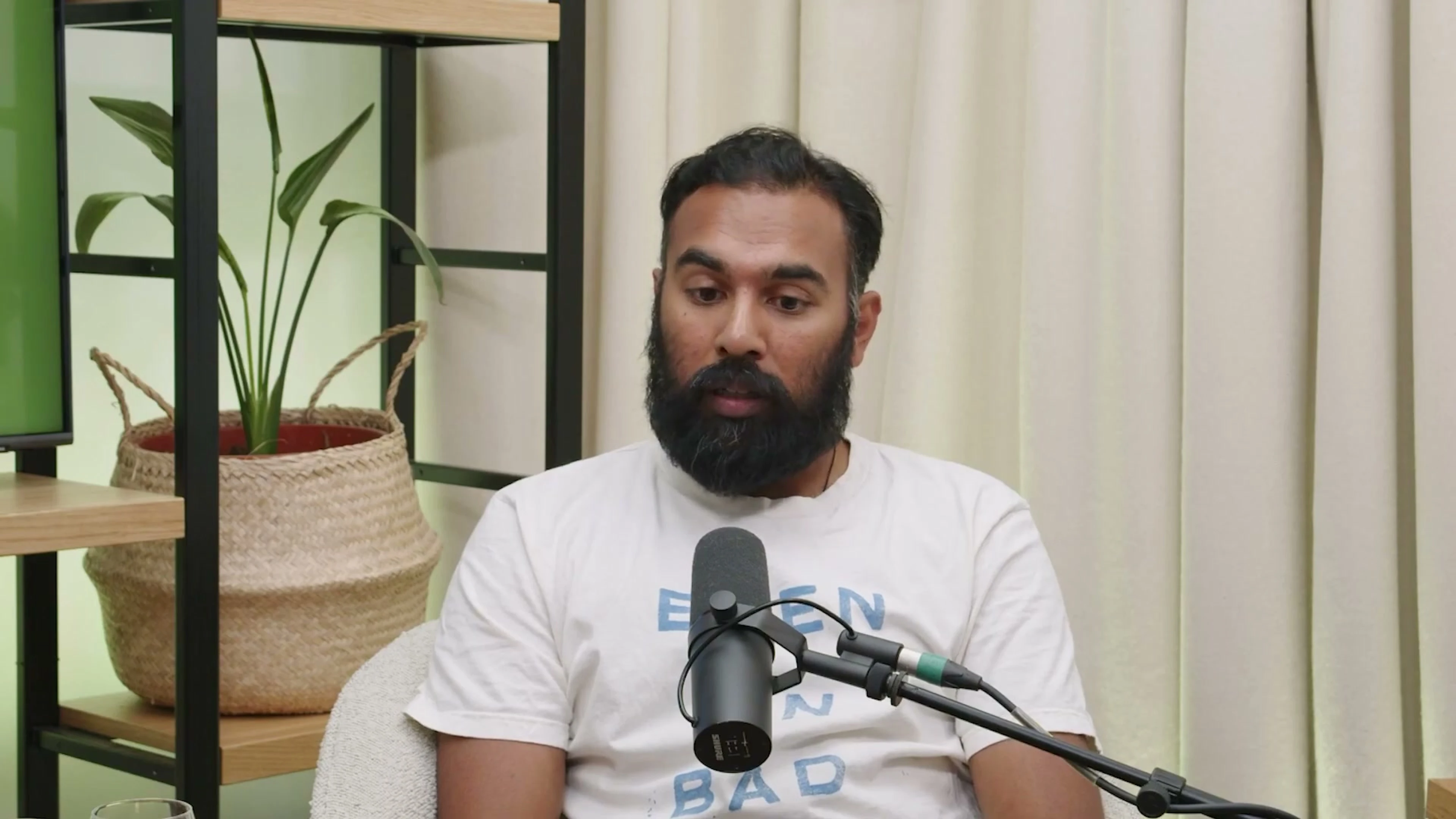Himesh Patel speaks during an interview, with a microphone in front of him.