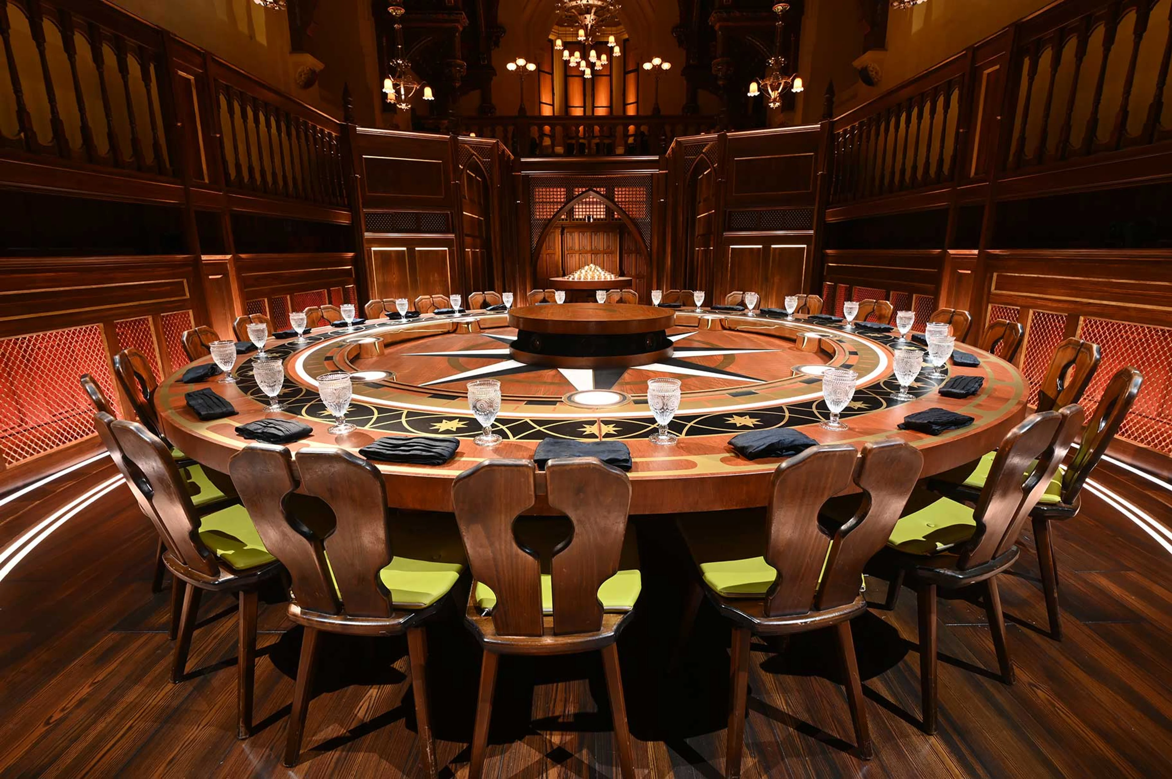 An empty circular table and chairs inside The Traitors Roundtable room.
