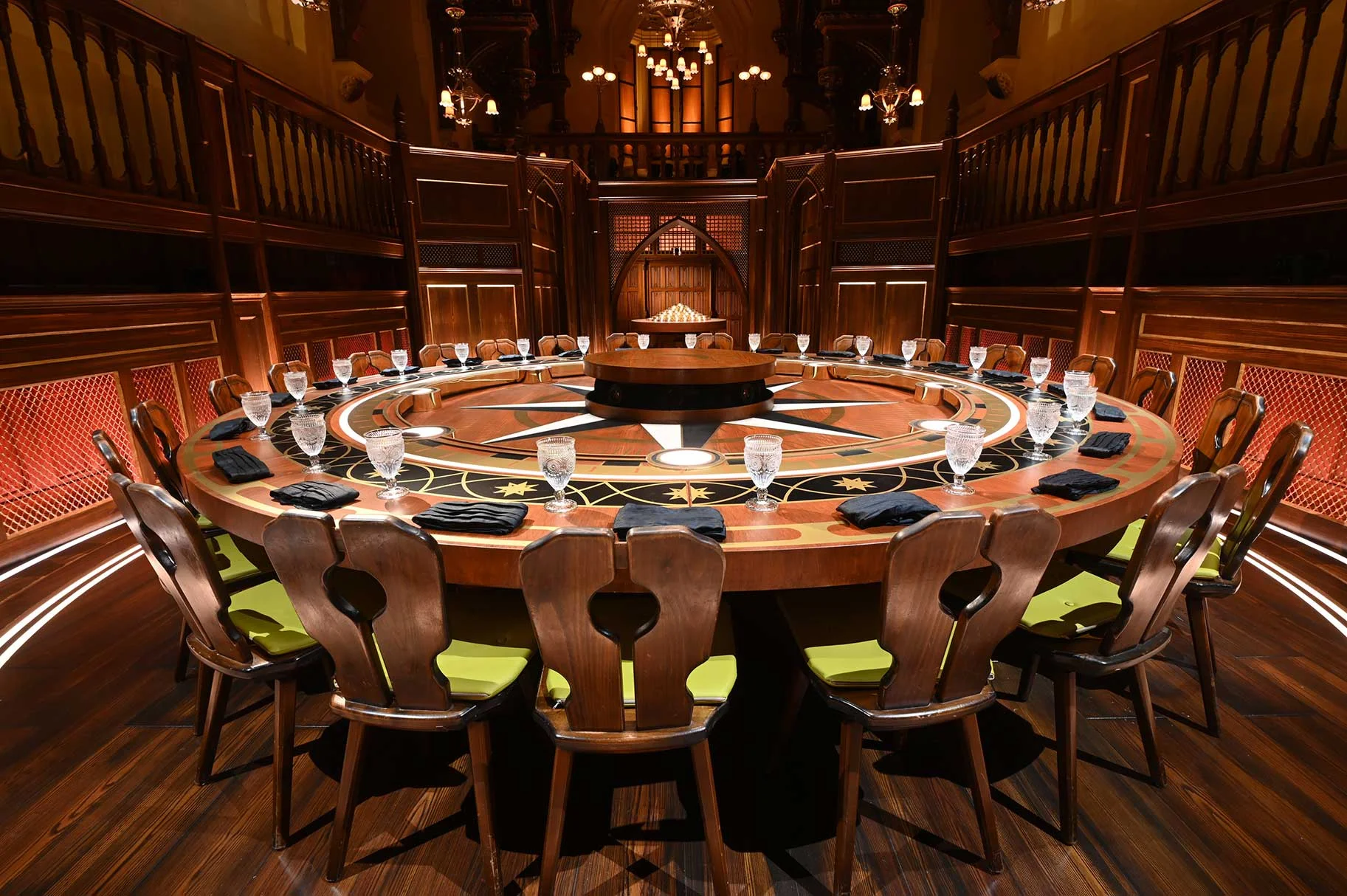 An empty circular table and chairs inside The Traitors Roundtable room.