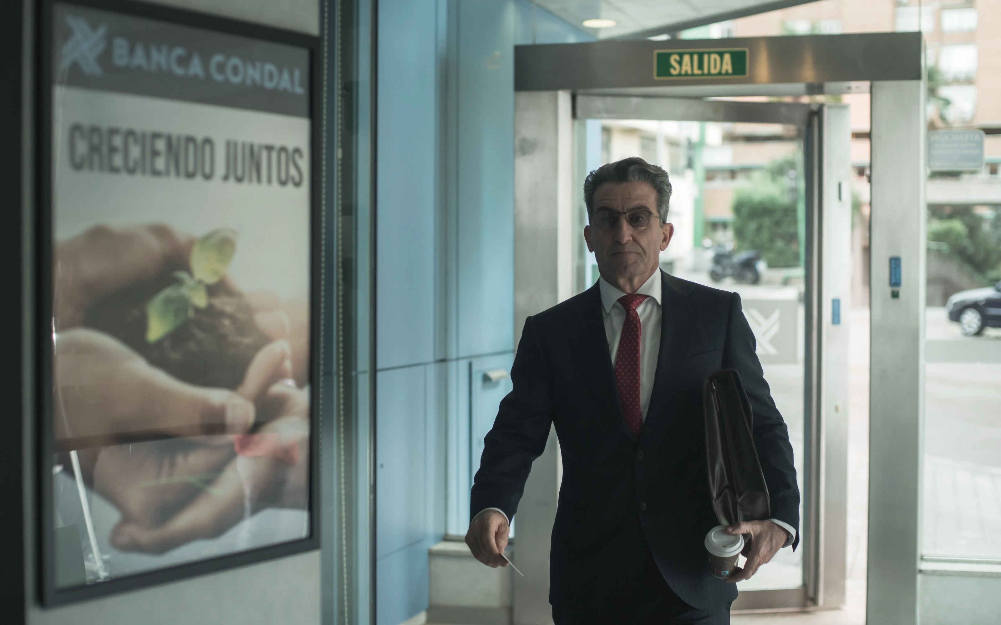A suited man walks into a bank lobby.