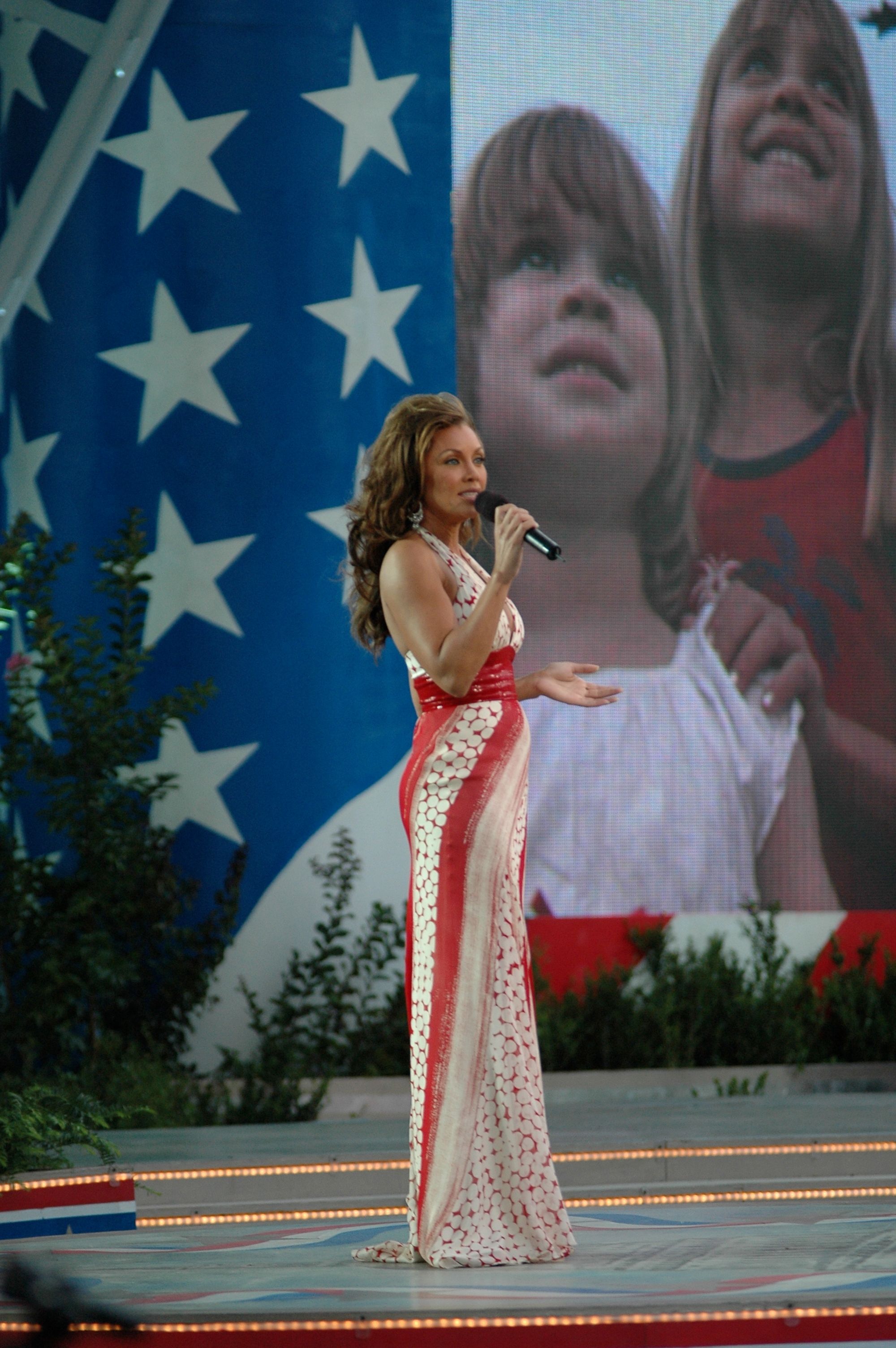 Vanessa Williams sings on stage, holding a microphone.
