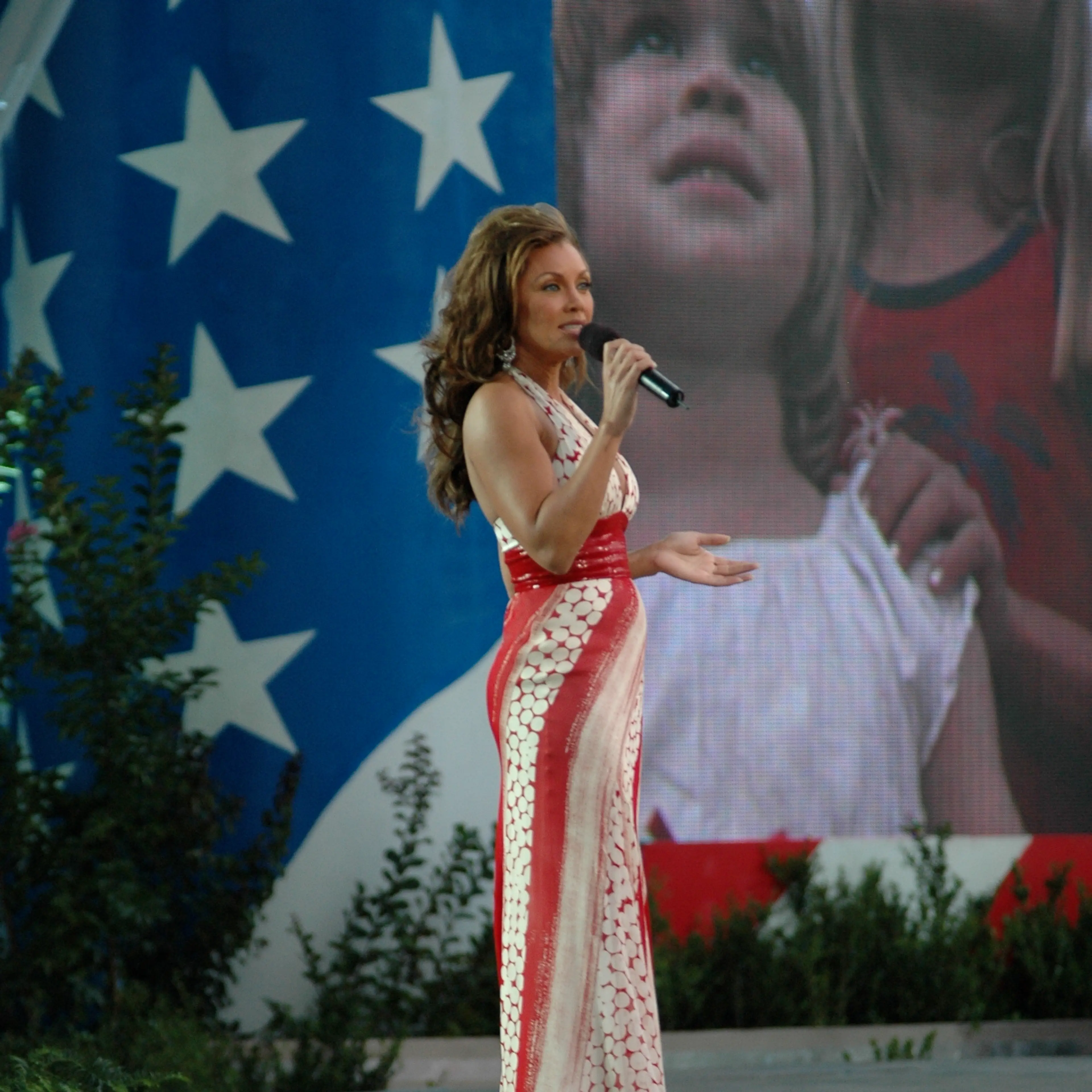 Vanessa Williams sings on stage, holding a microphone.
