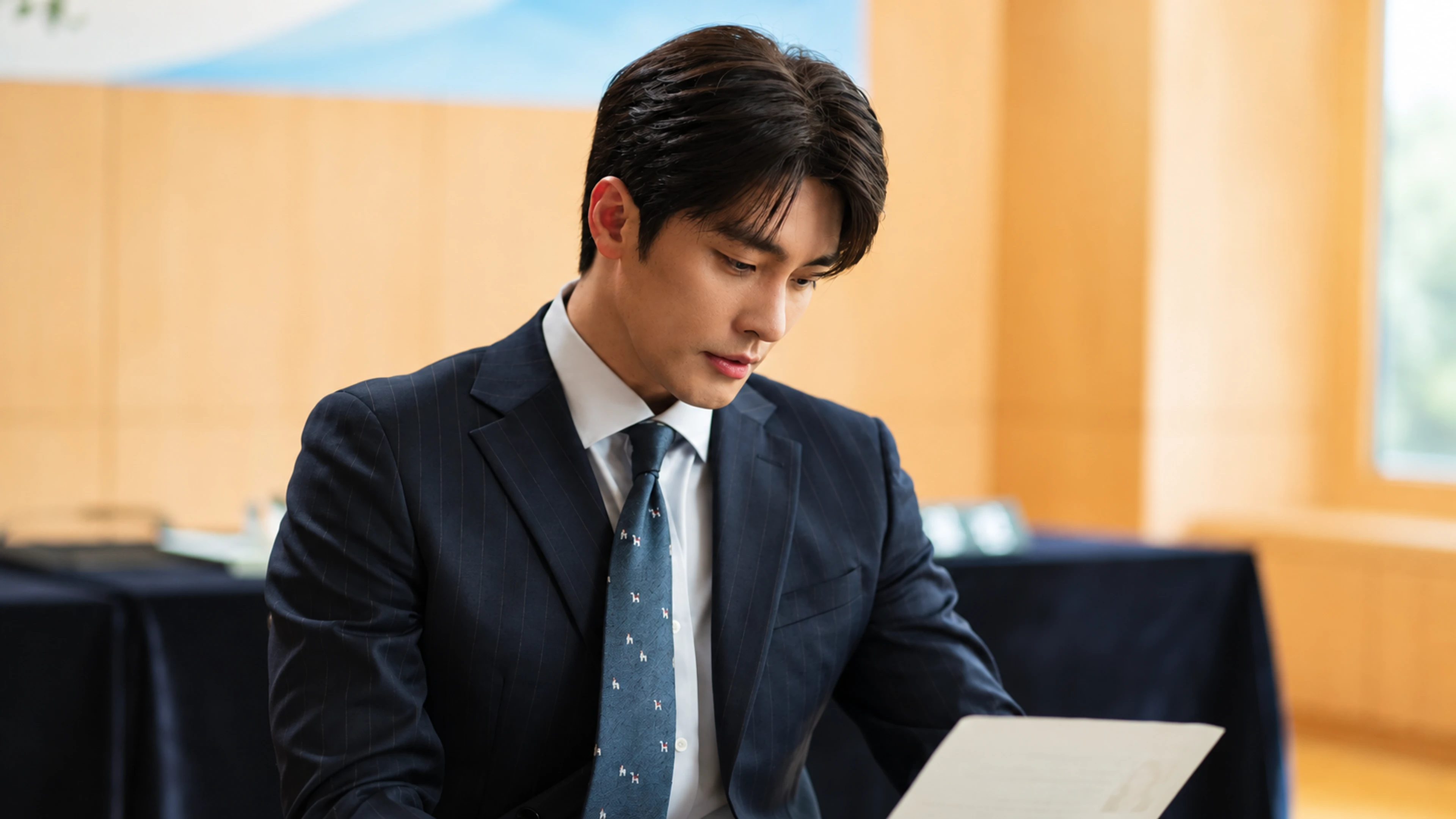 Sung Hoon as Kwon Do-hyuk looks down at a document in What a Boss Wants.