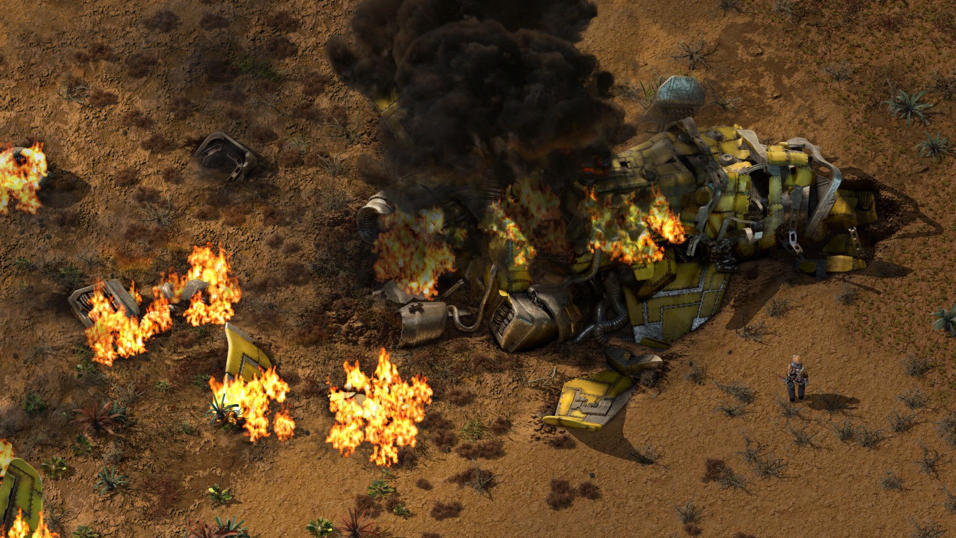 Burning wreckage lies on bare ground beside the engineer.