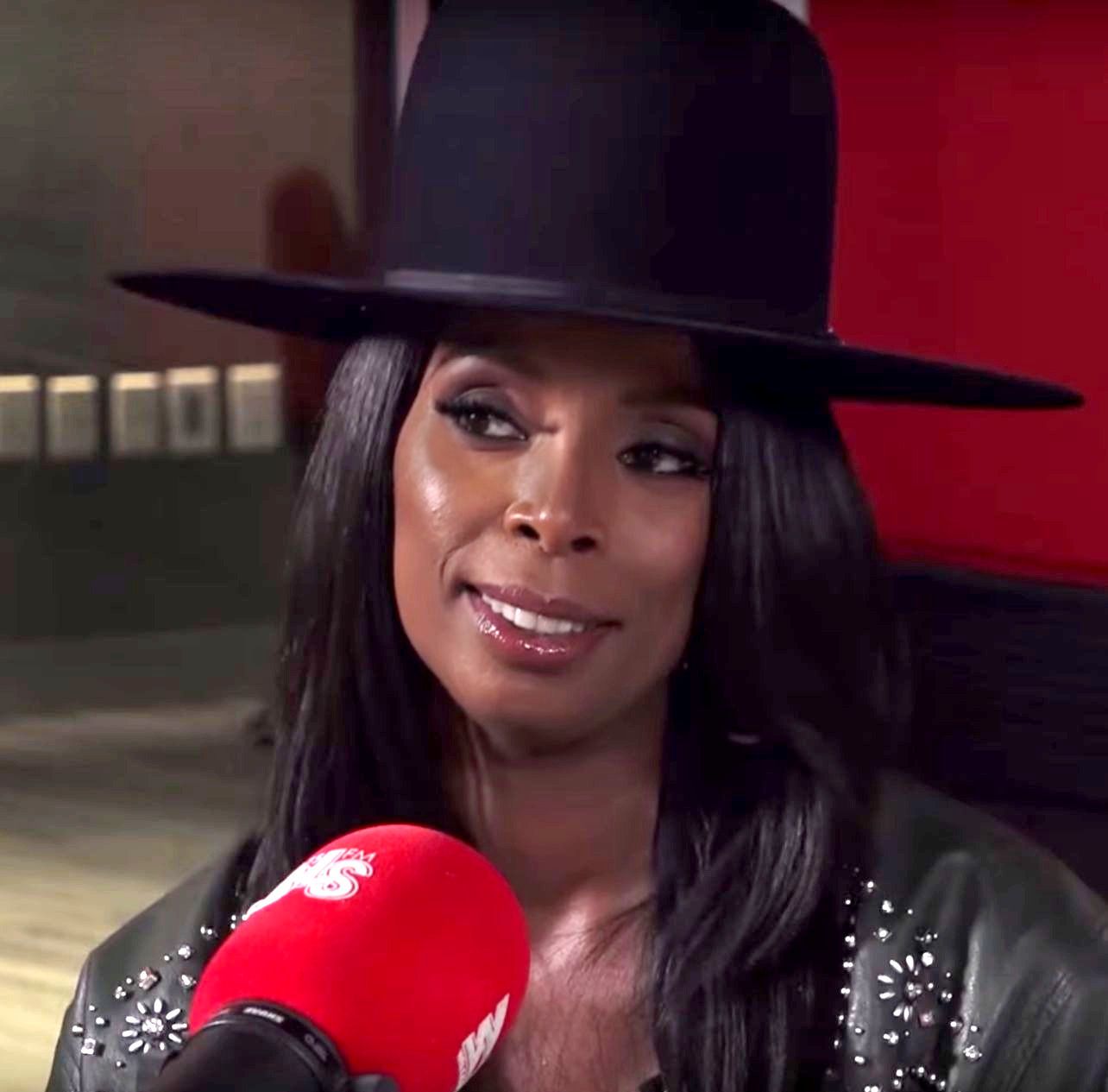 Tasha Smith wearing a black hat during a 2017 interview.