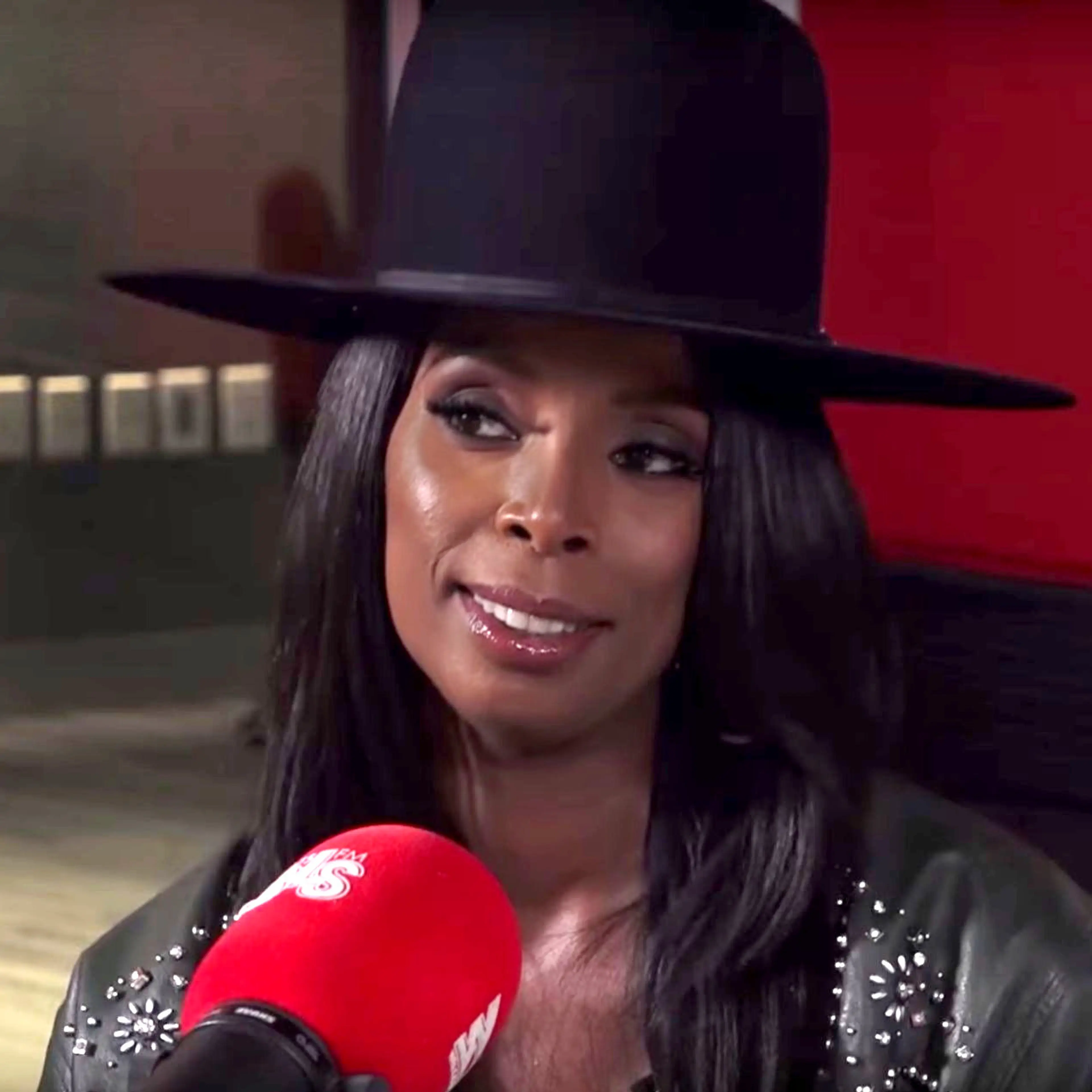 Tasha Smith wearing a black hat during a 2017 interview.