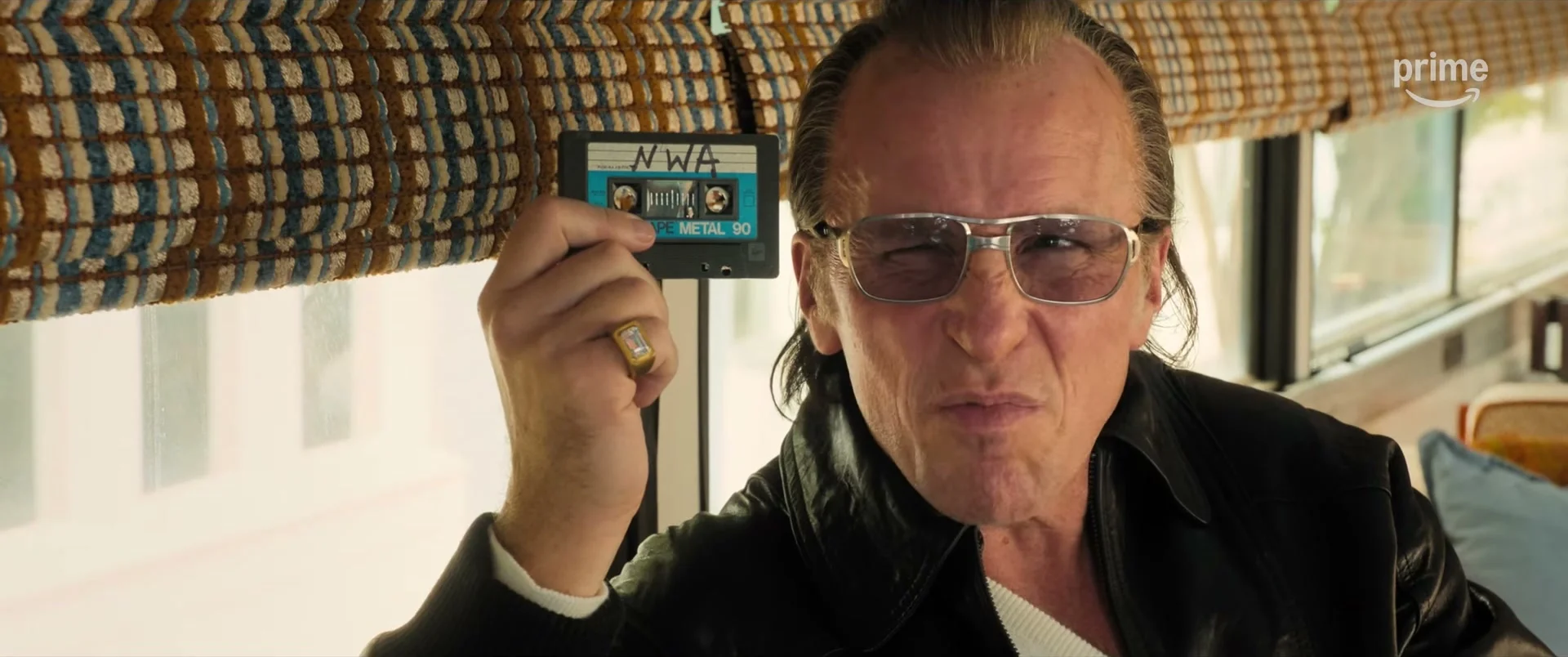 Christian Bale as Al Davis holds a cassette tape in the Madden trailer.