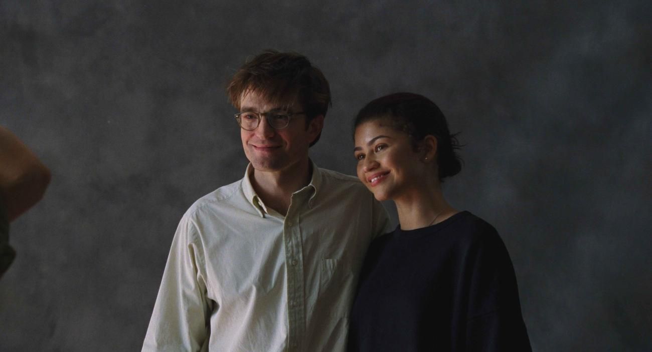 Charlie and Emma pose together against a gray photography backdrop.