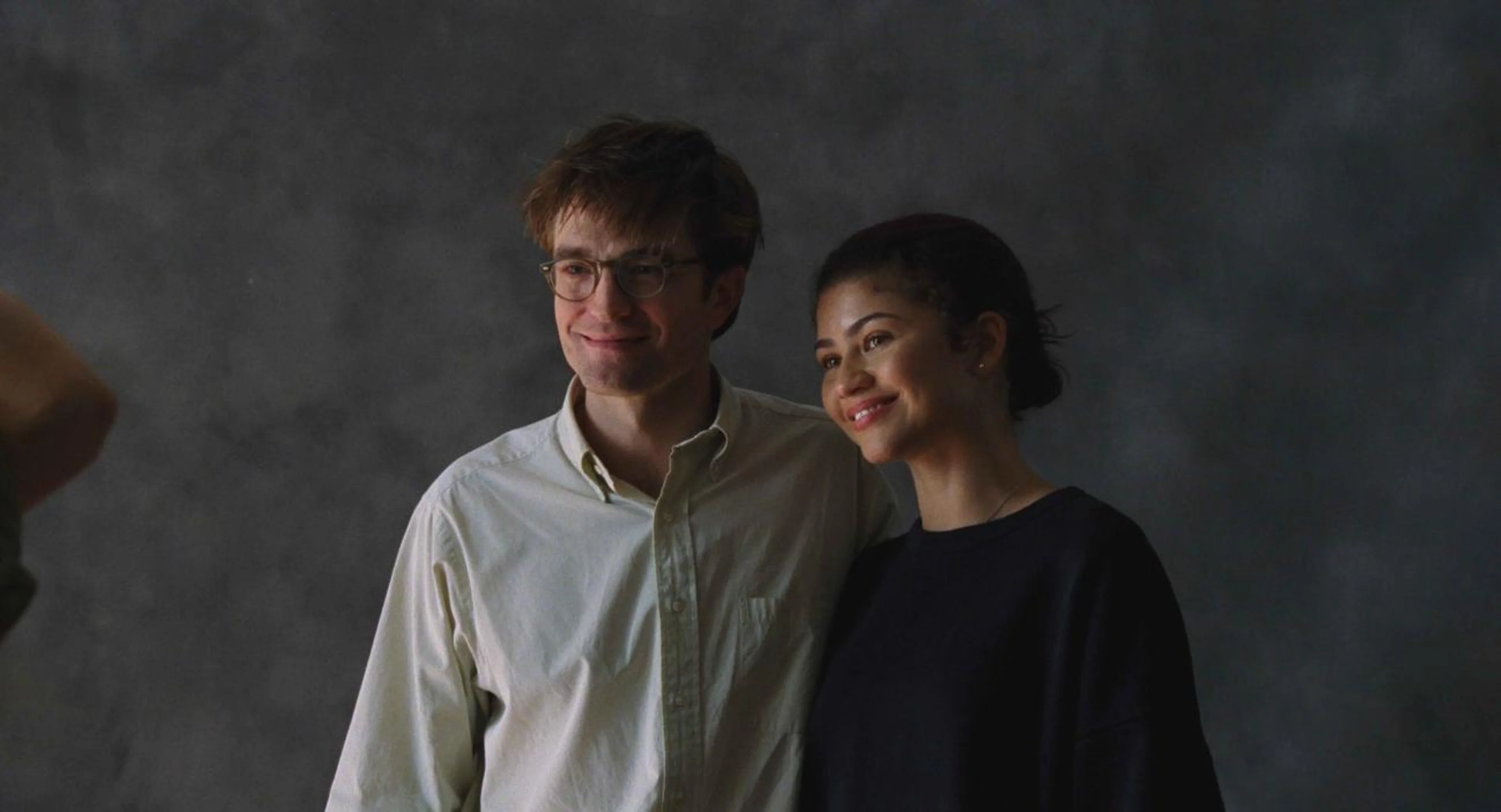 Charlie and Emma pose together against a gray photography backdrop.