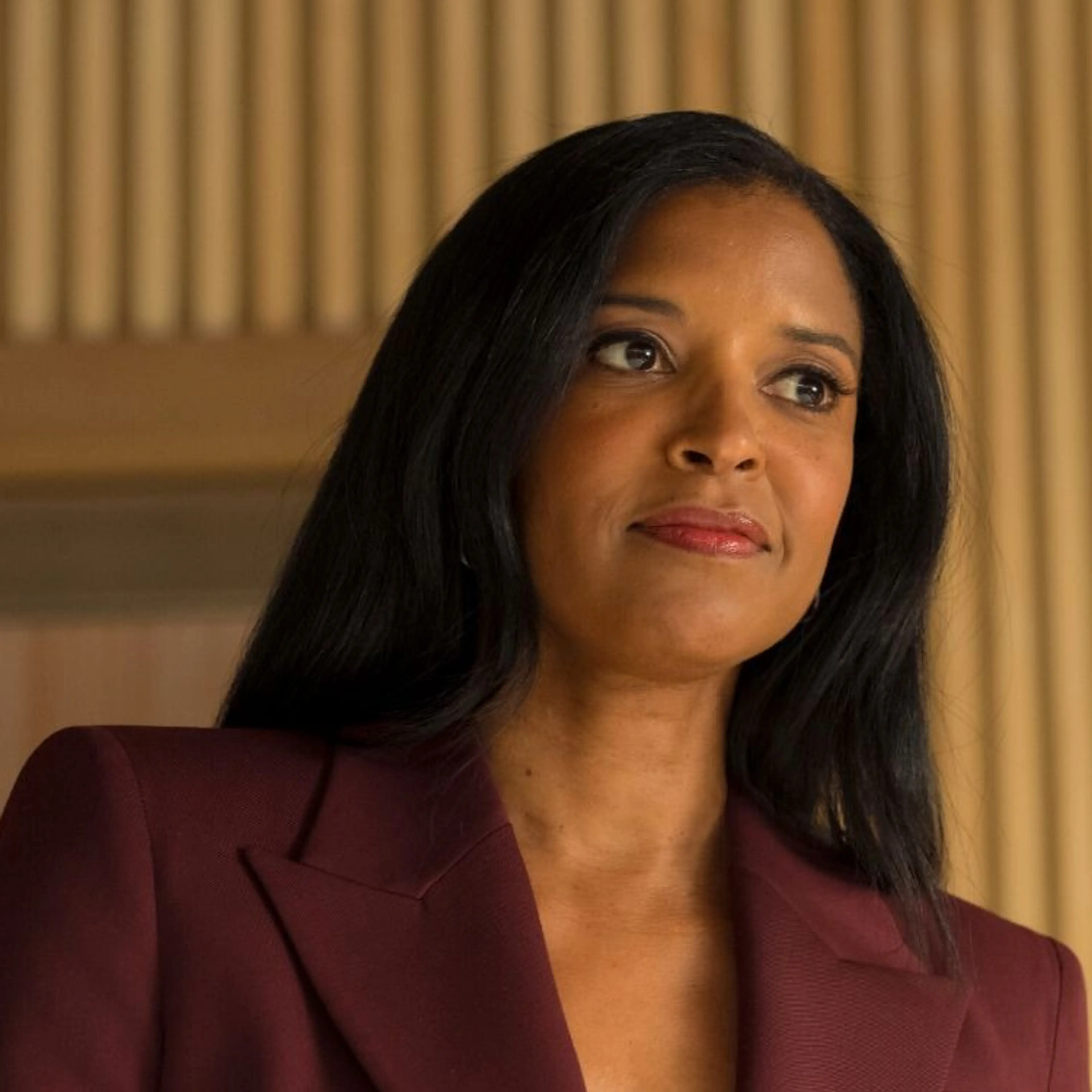 Renée Elise Goldsberry as Nichole E. Ferebee, wearing a burgundy suit in an official Cupertino production photograph.