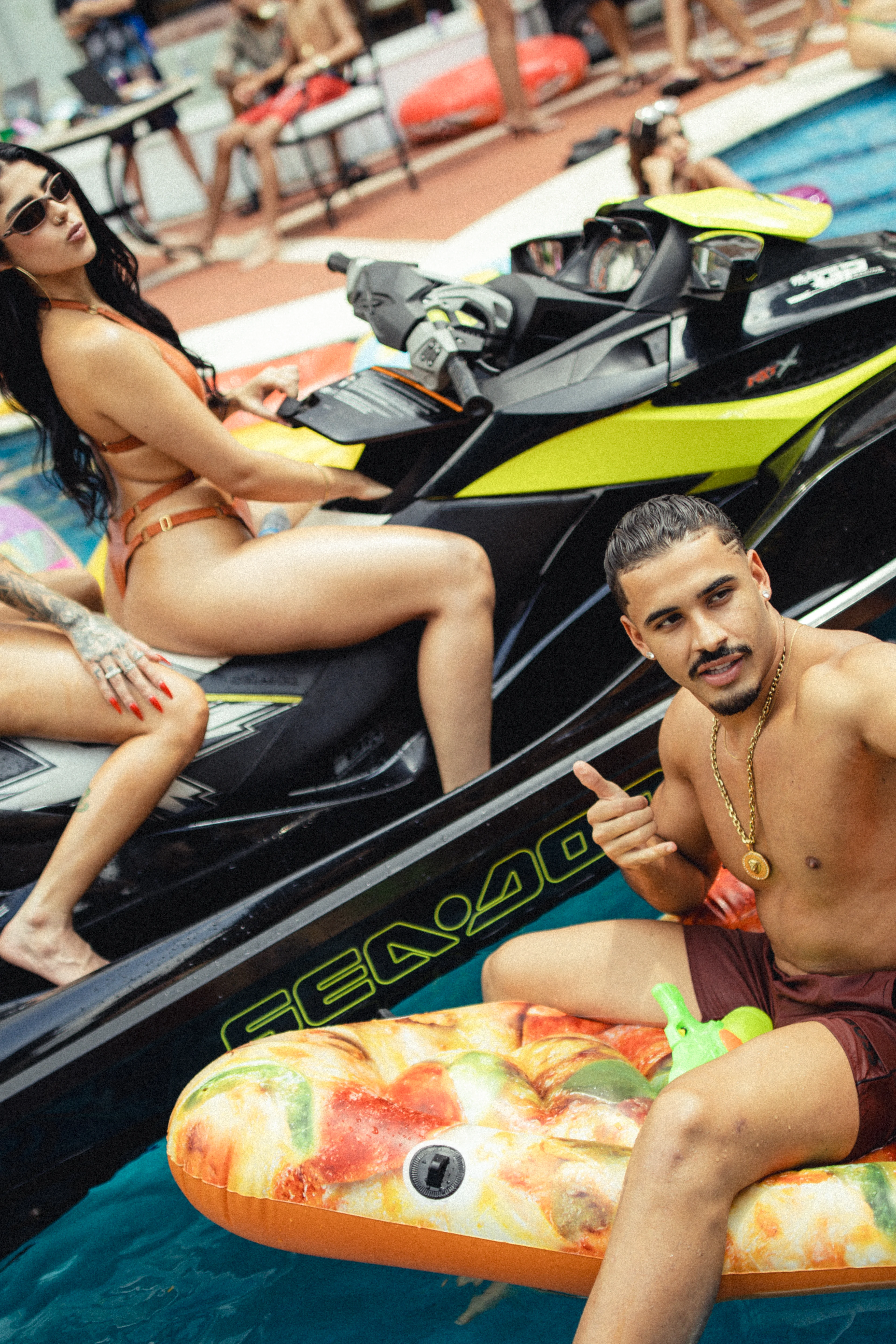 Three Rauls cast members pose with a jet ski and pool floats during the teaser shoot.
