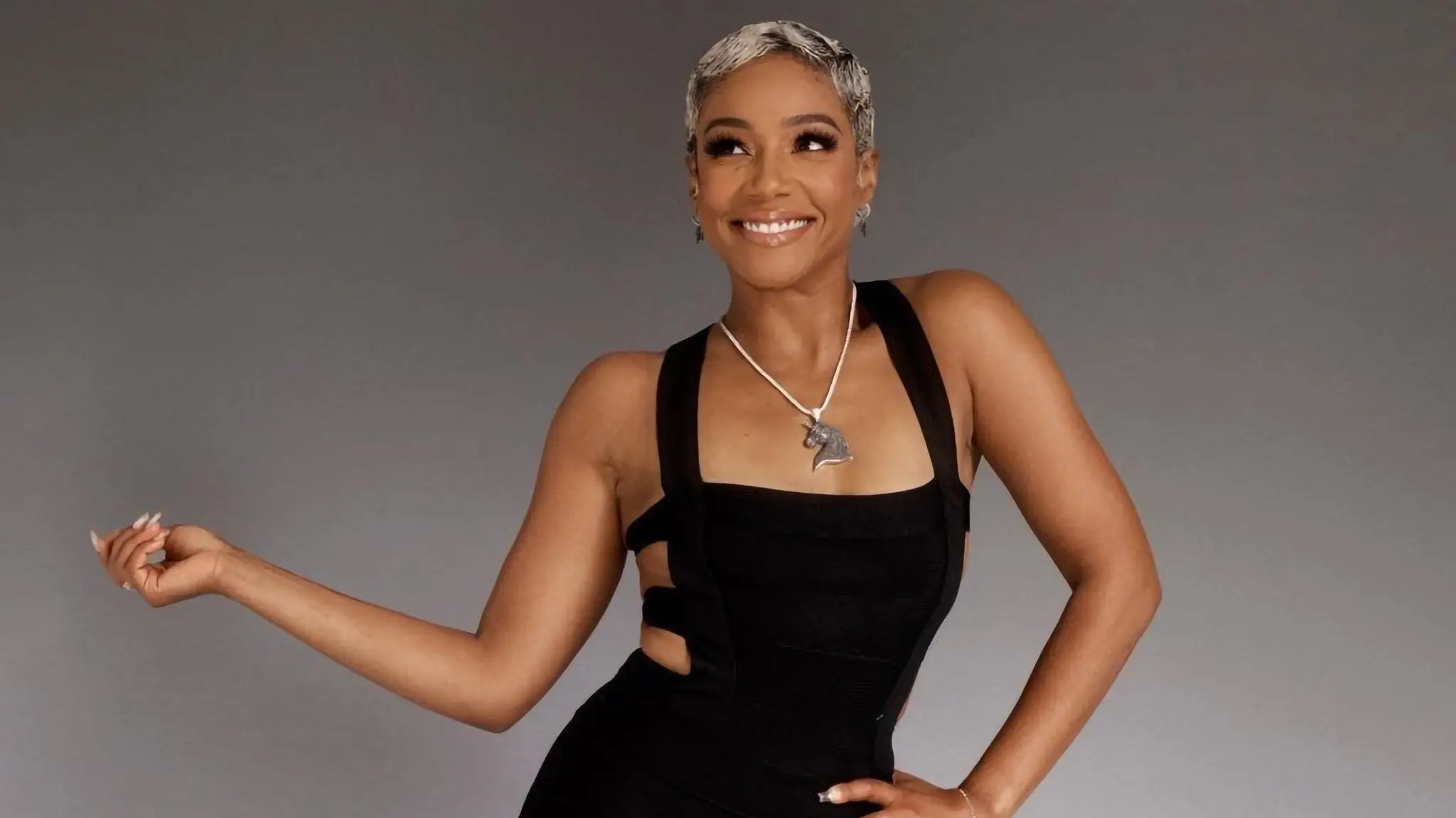 Tiffany Haddish smiles in a black dress in her Live Nation 2026 promotional portrait.