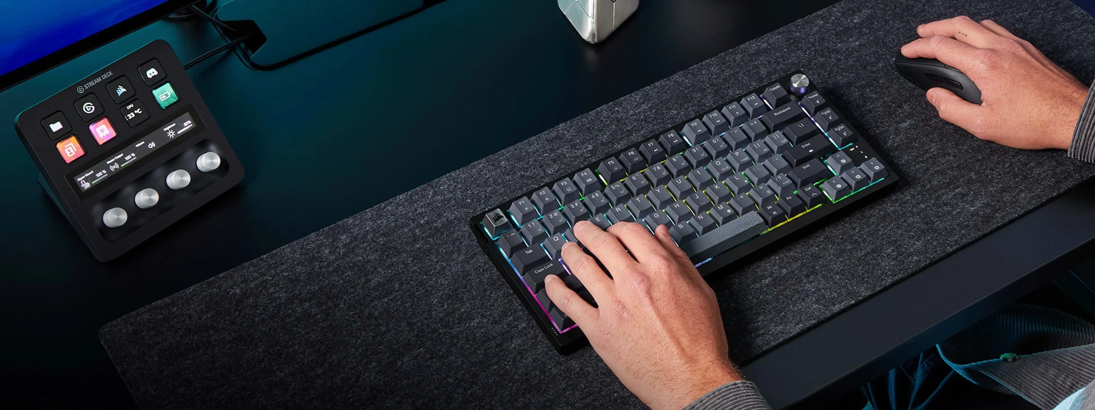Hands typing on the K65 Plus Wireless beside a mouse