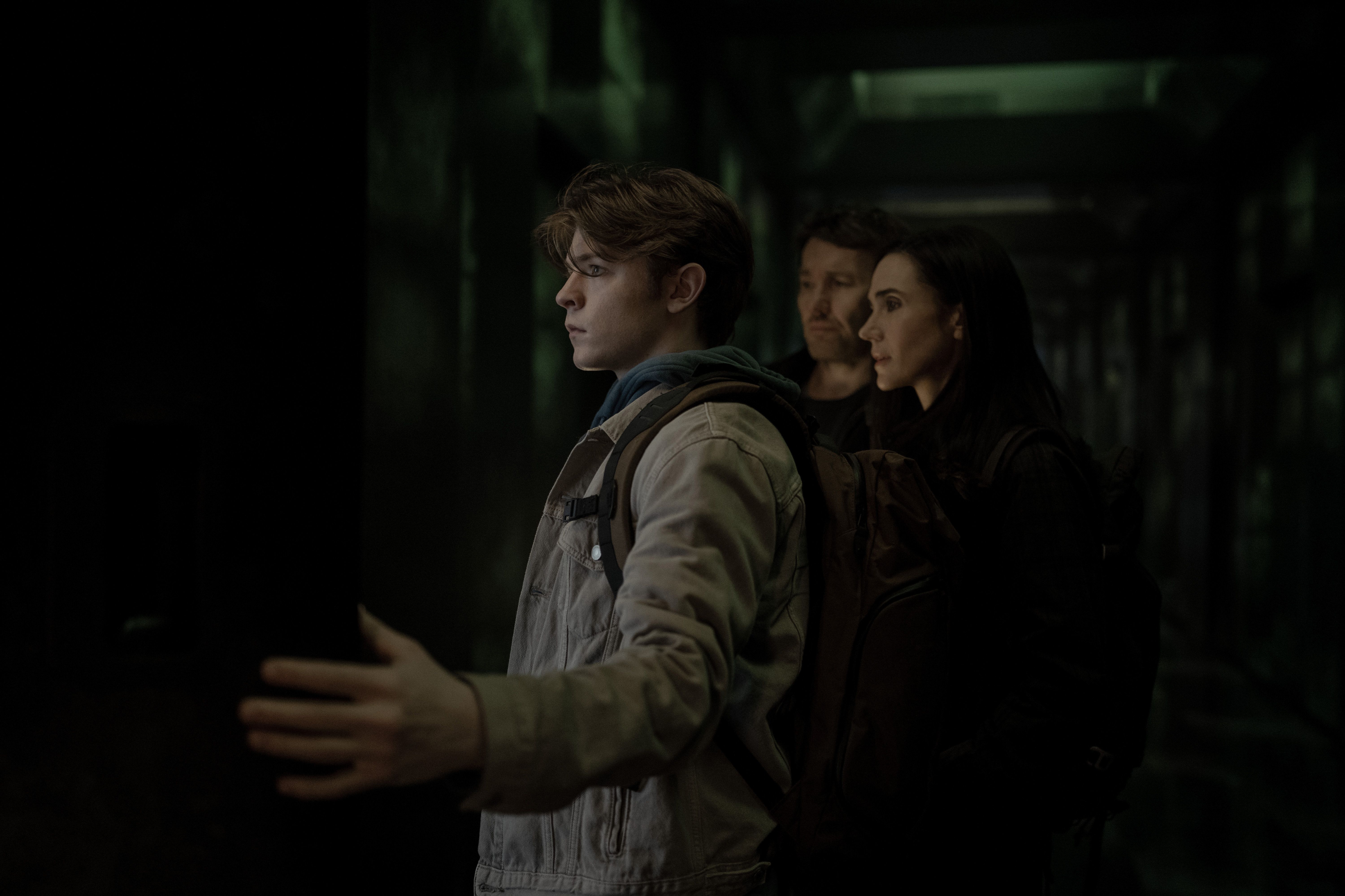 Oakes Fegley stands in front of Joel Edgerton and Jennifer Connelly in Dark Matter Season 2.