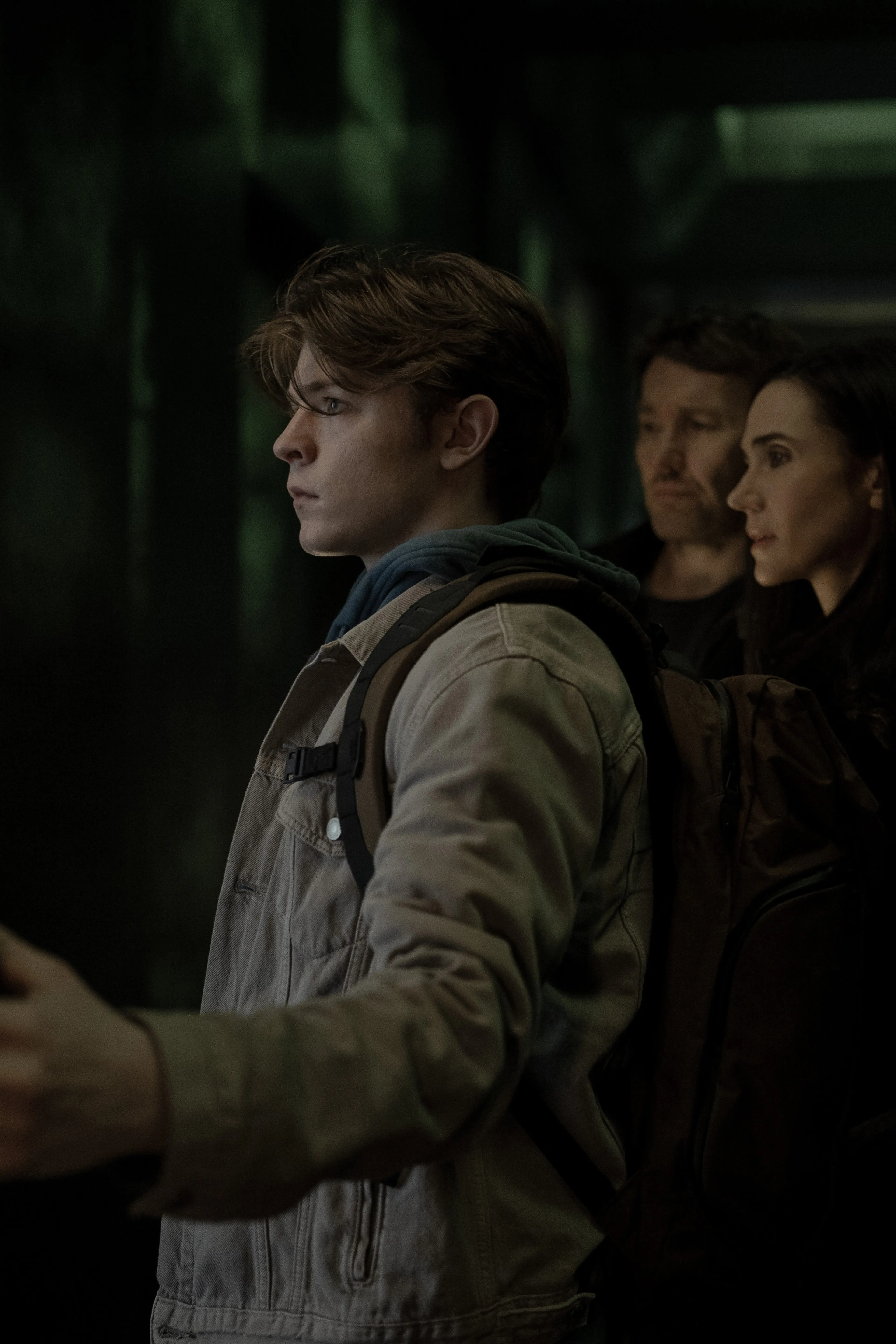 Oakes Fegley stands in front of Joel Edgerton and Jennifer Connelly in Dark Matter Season 2.