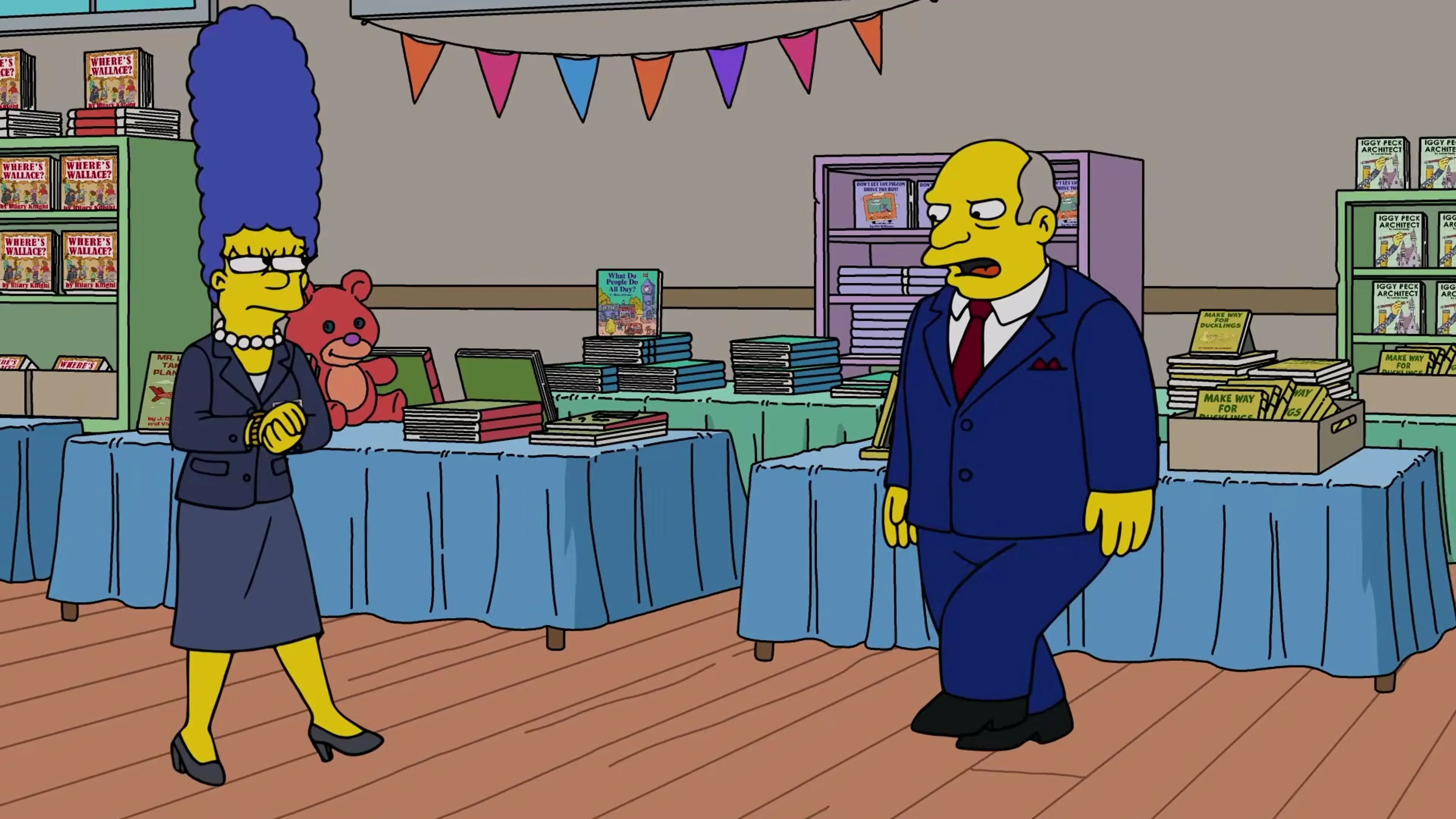 Marge Simpson stands beside the visiting author at the school book fair.