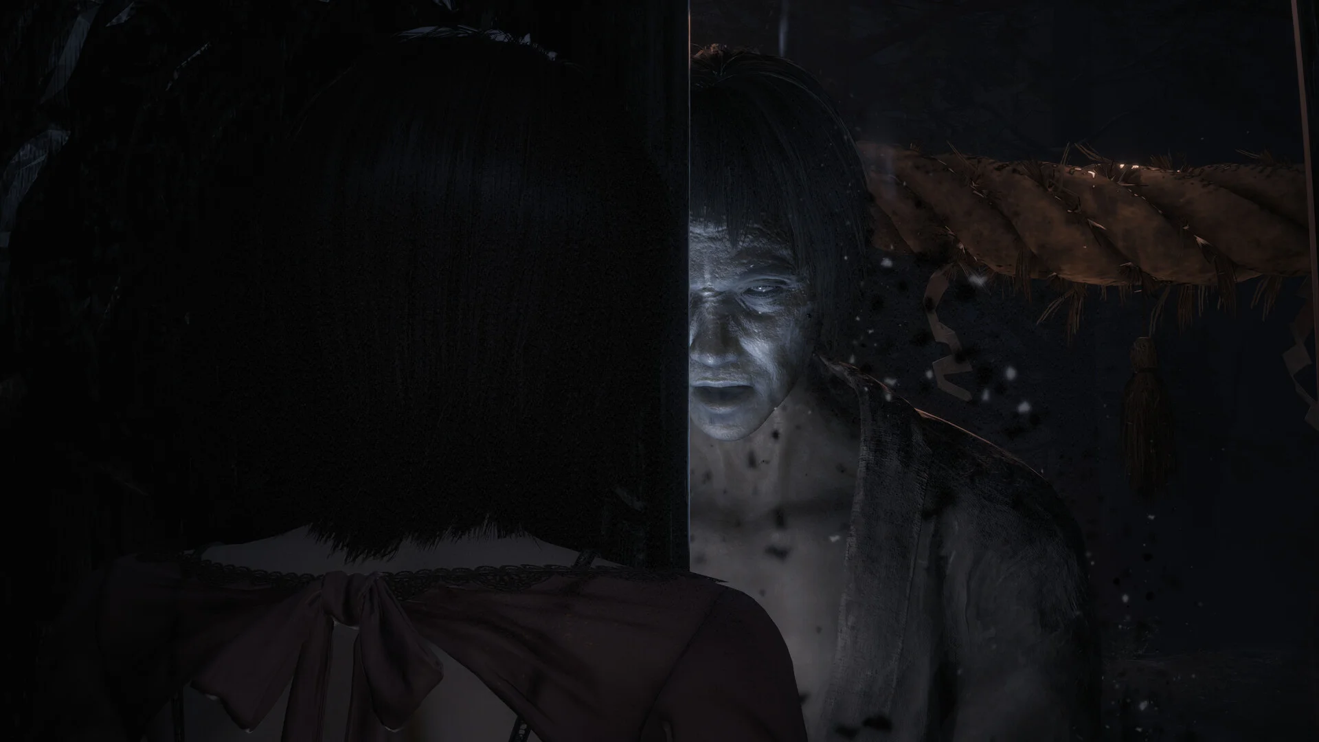 A pale ghost appears inches behind Mio in Fatal Frame II: Crimson Butterfly Remake.