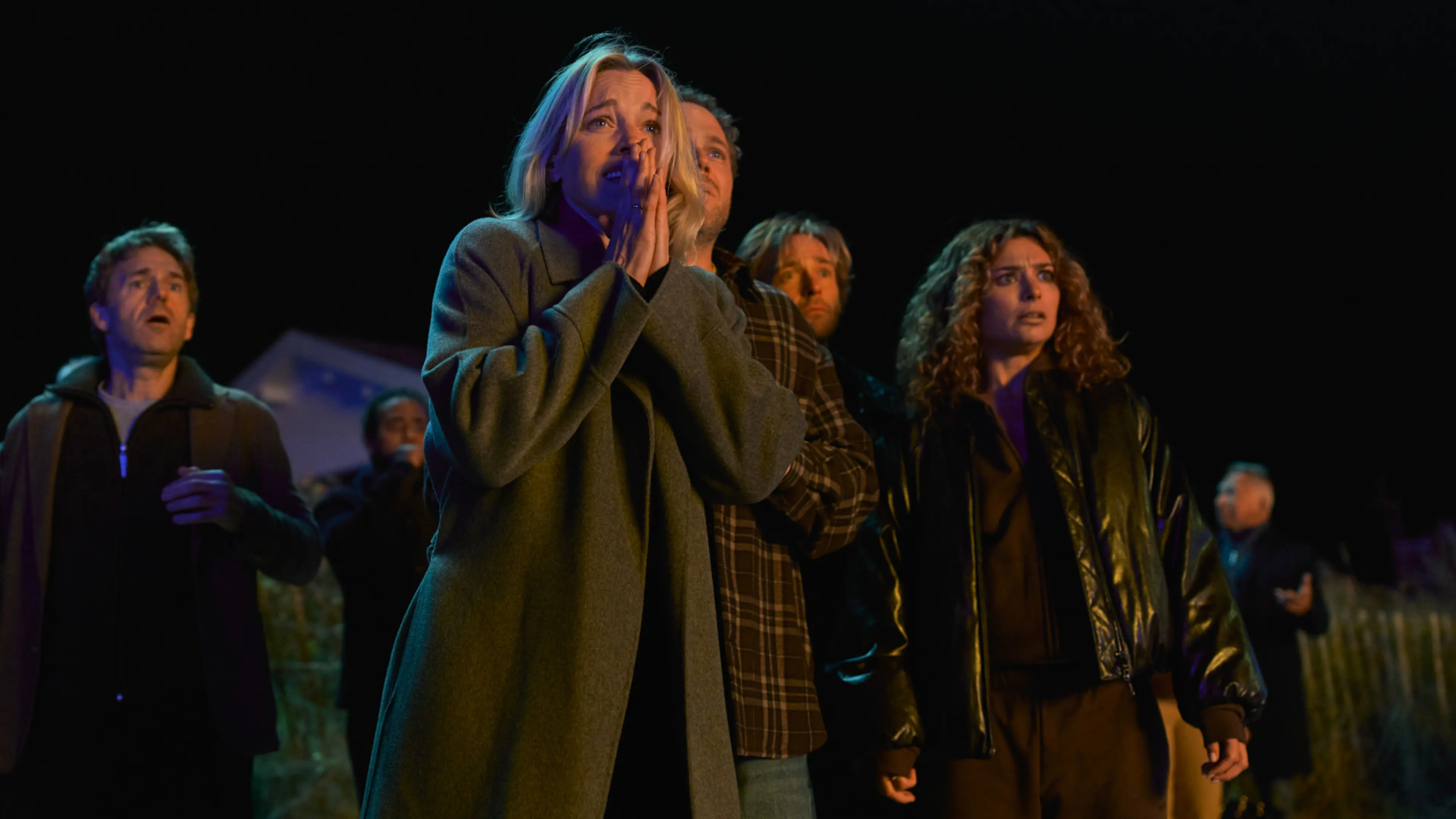 Members of the dinner club react outdoors at night in The Perfect Lie.