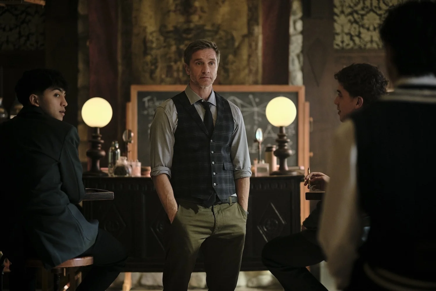 Devon Sawa as Mr. Cole stands between two students at Coven Academy.