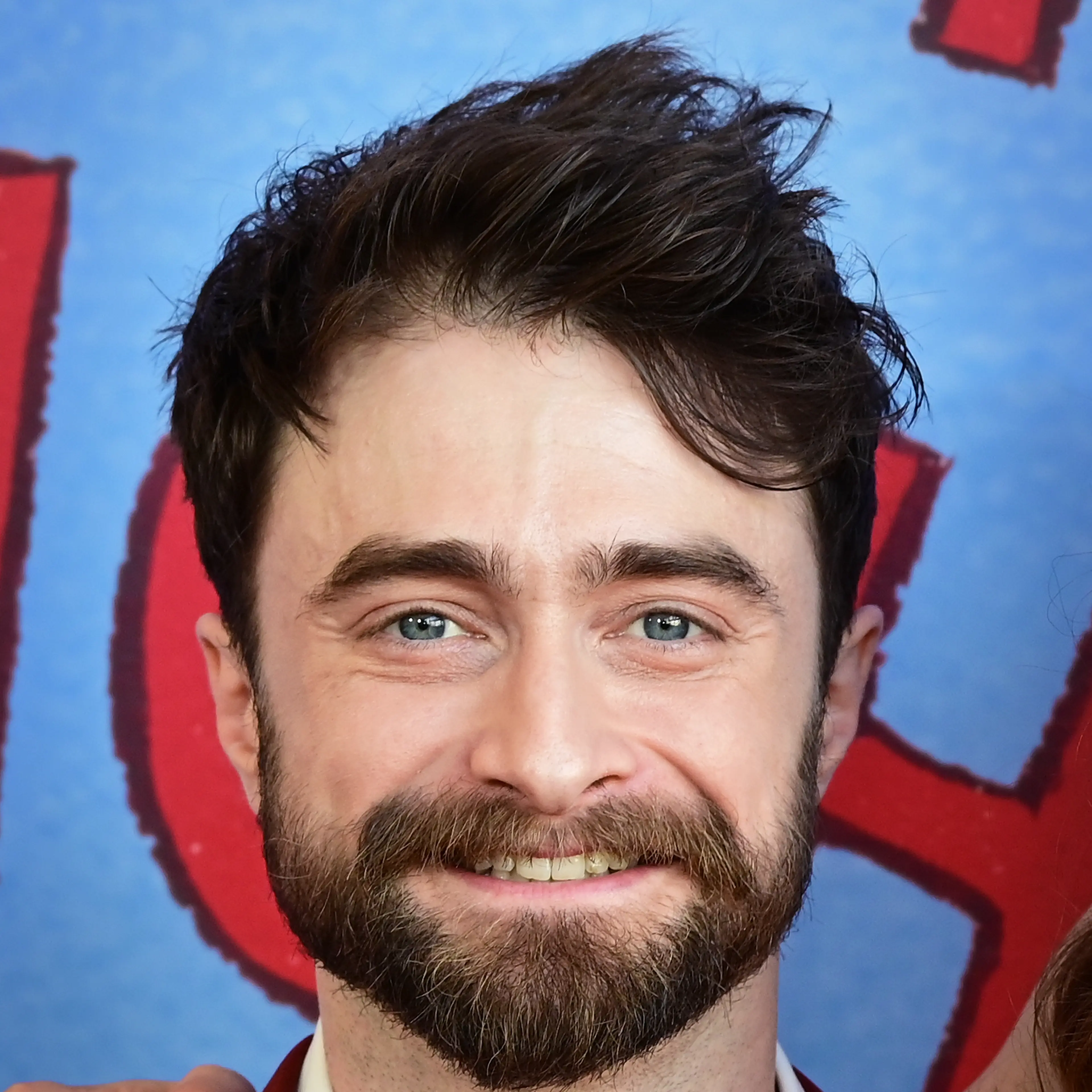 Daniel Radcliffe smiling with dark hair and a beard at the Lincoln Center Theater Gala in May 2026.