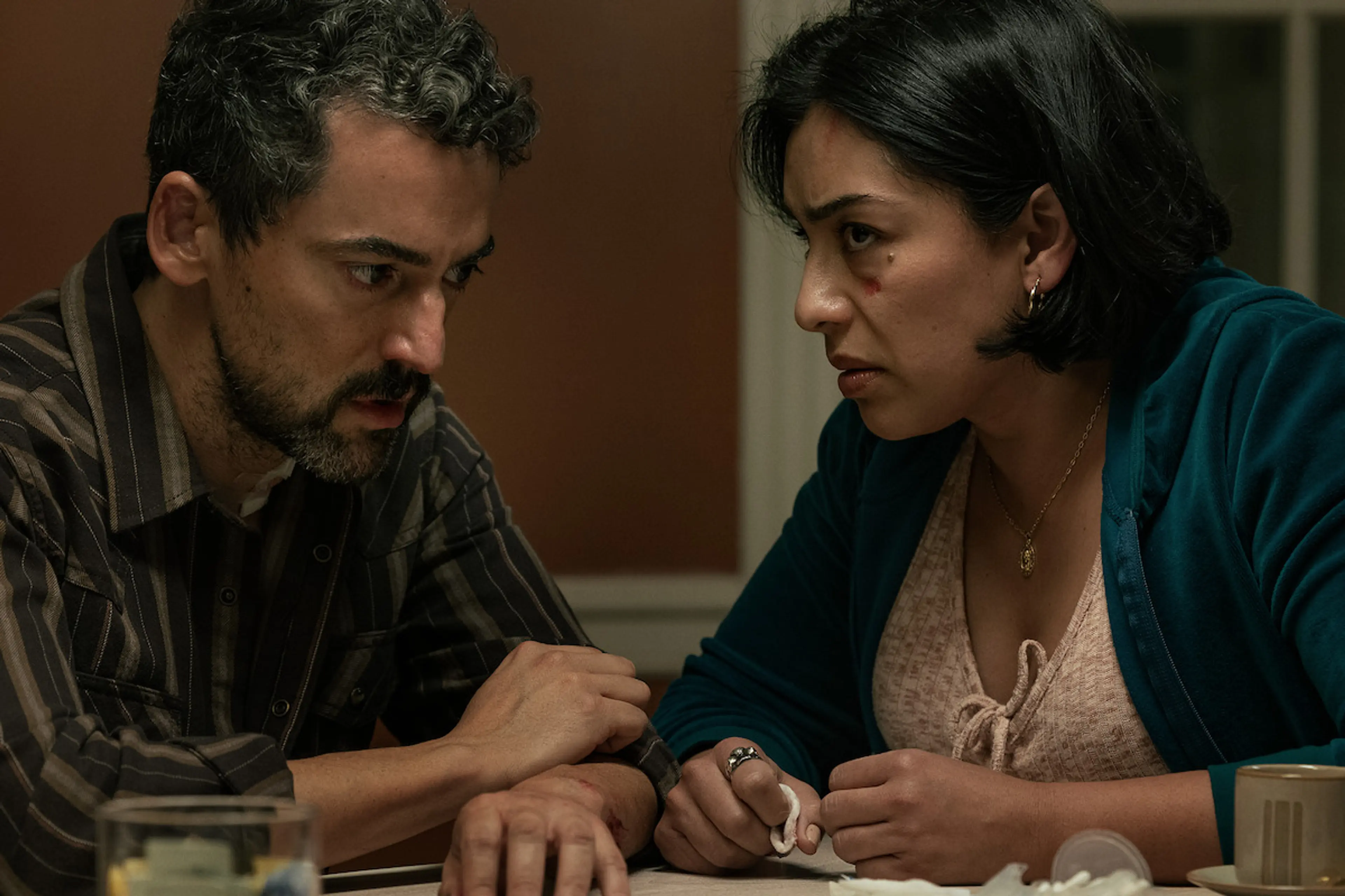Luis Gerardo Méndez and Adriana Paz sit close together at a table in Animals.