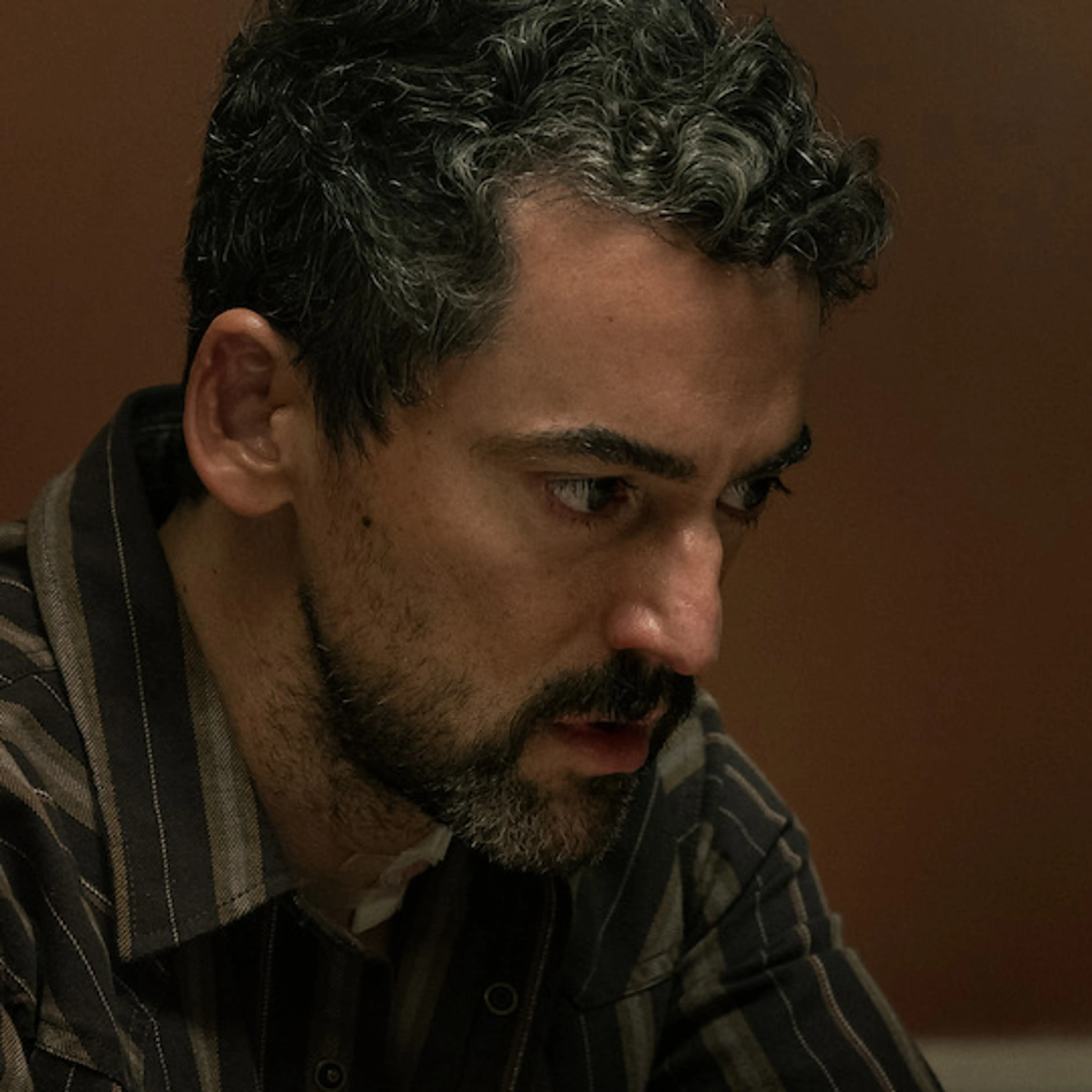 Luis Gerardo Méndez in an official Animals production photograph, seated at a table.