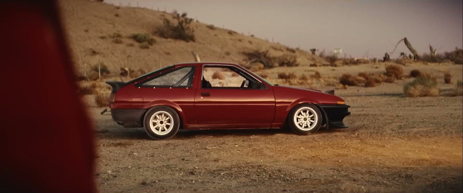 A red Toyota AE86 called Lola stands in the desert in Drifter.